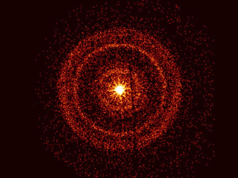 rings of red particles radiate outward from a bright yellow center