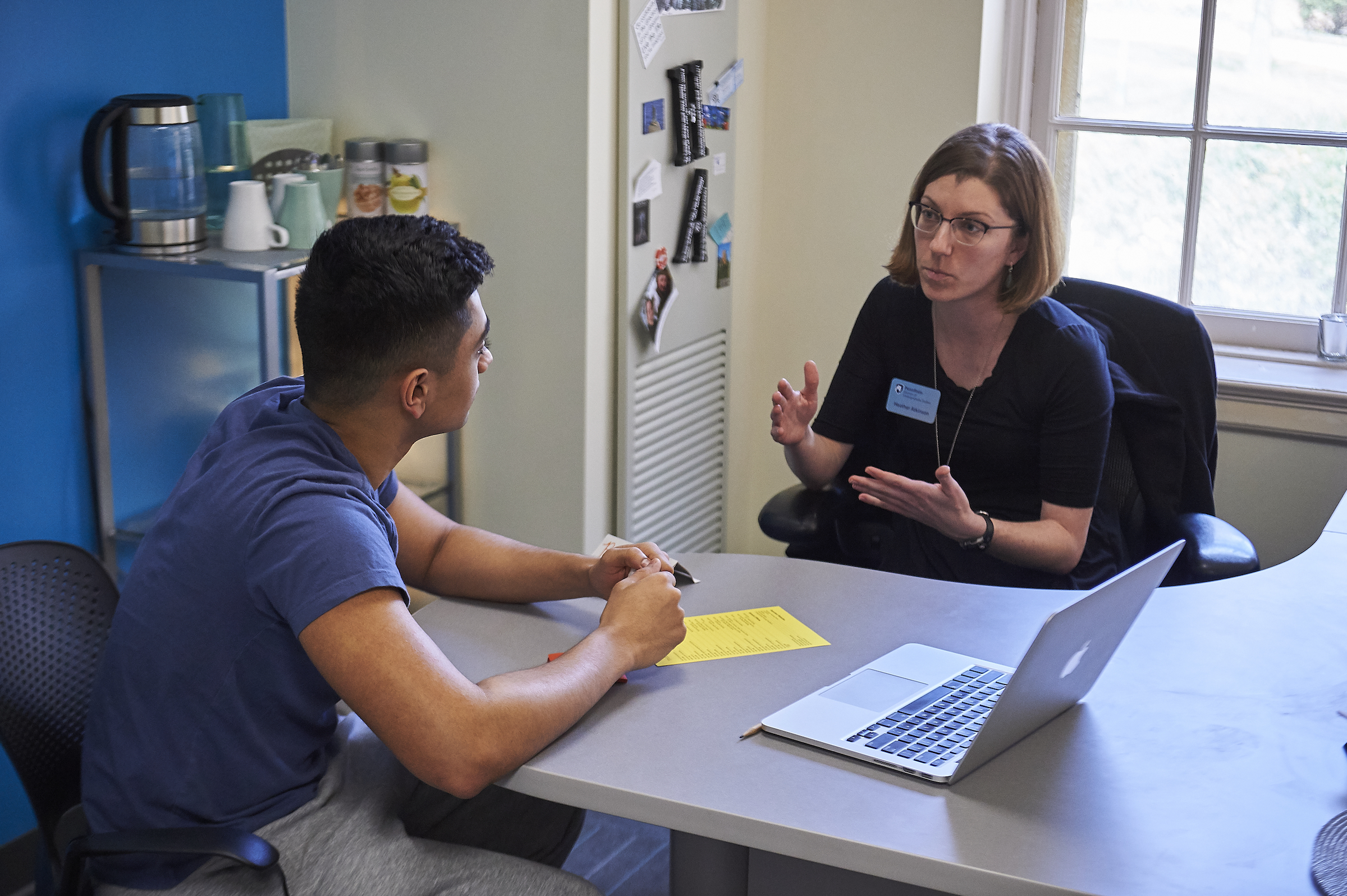 Student talking with academic adviser in an office