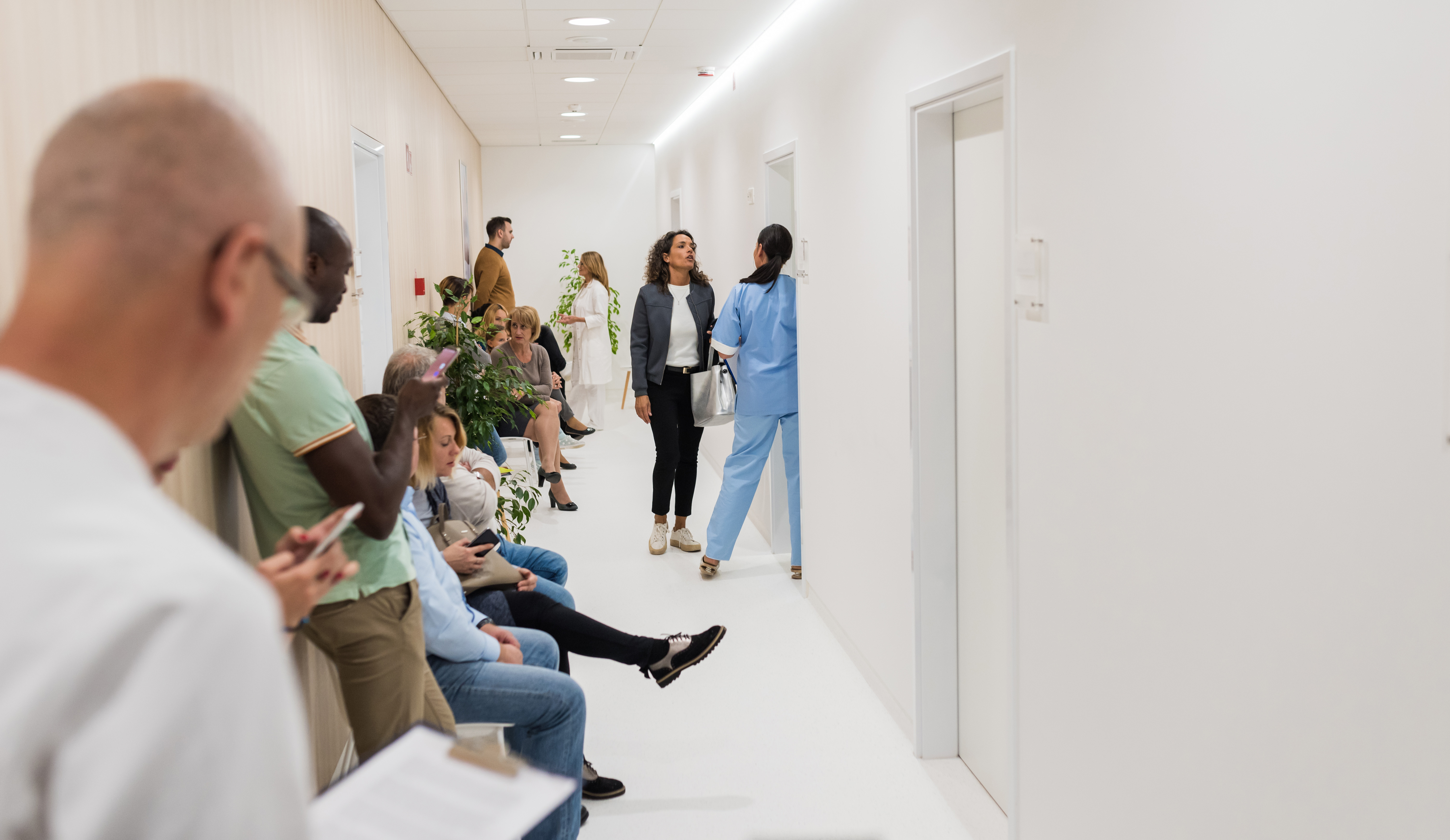 Hallway in a hospital filled with people waiting