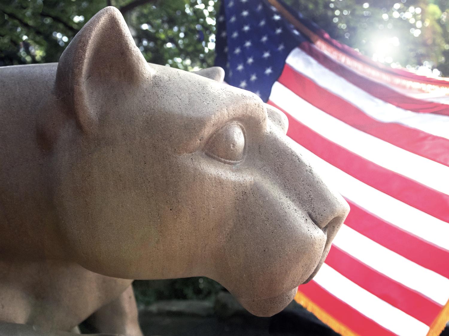 The Nittany Lion Shrine with an American flag in the background.