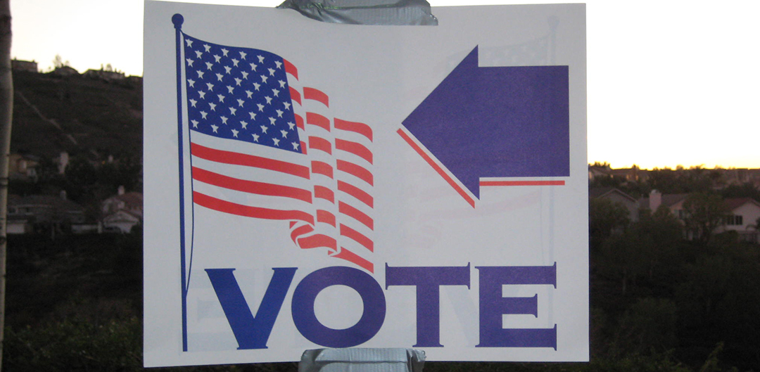 Voting sign taped to a light pole