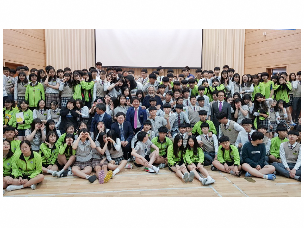 A large gathering of students poses for a photograph in an auditorium