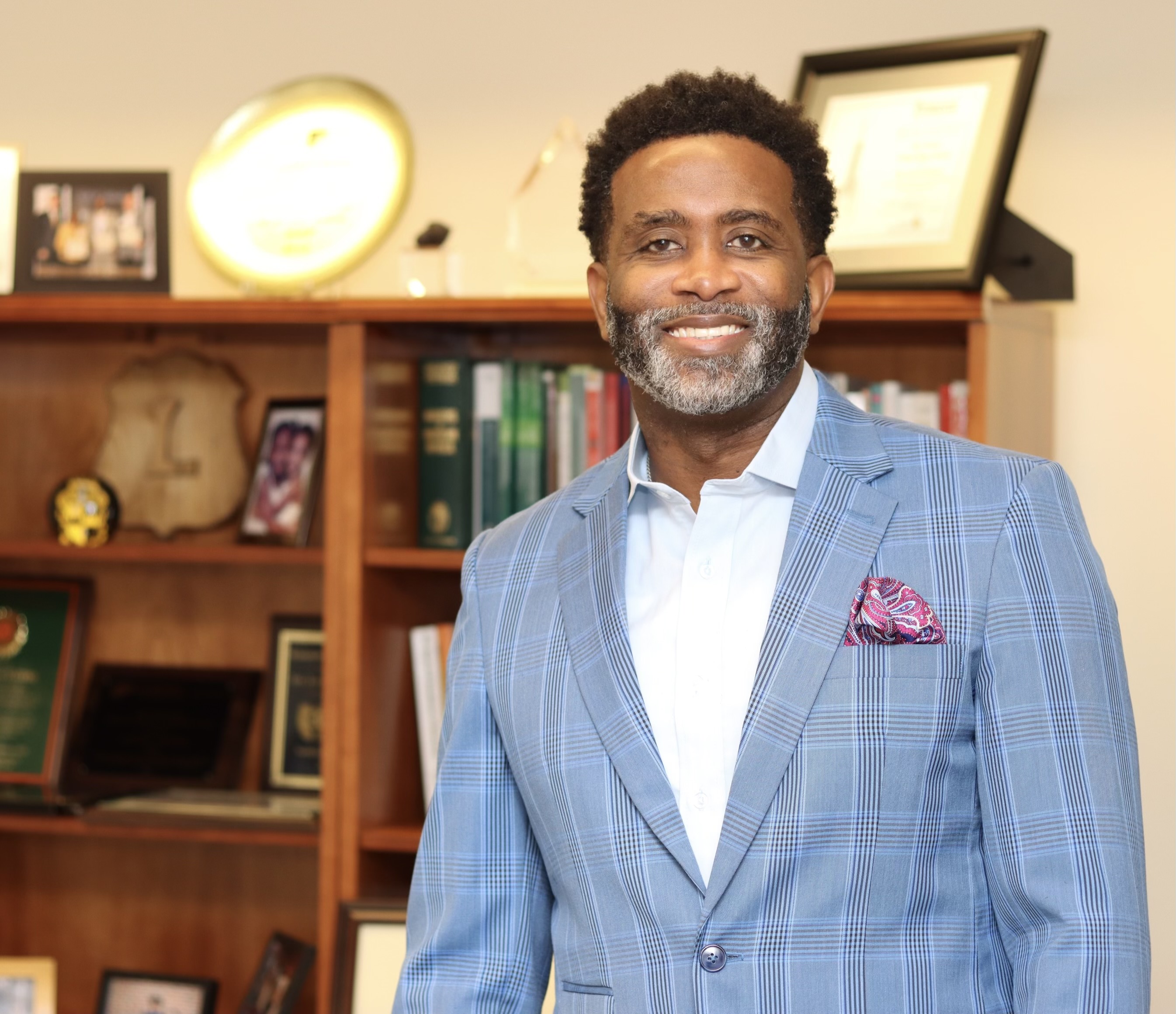 Levon Esters pictured in an office with a bookshelf in the background.