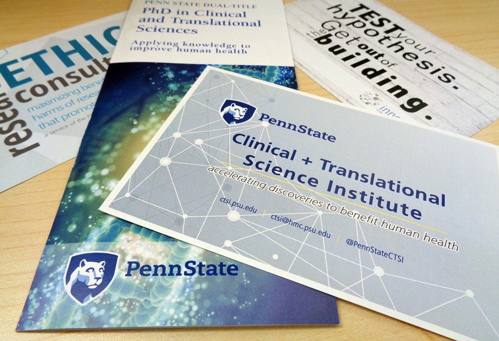 A pile of brochures advertising Penn State Clinical and Translational Science resources lays on a desk. 