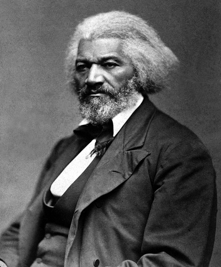 A man of color with a full head of hair and beard sits looking pensive in a portrait.