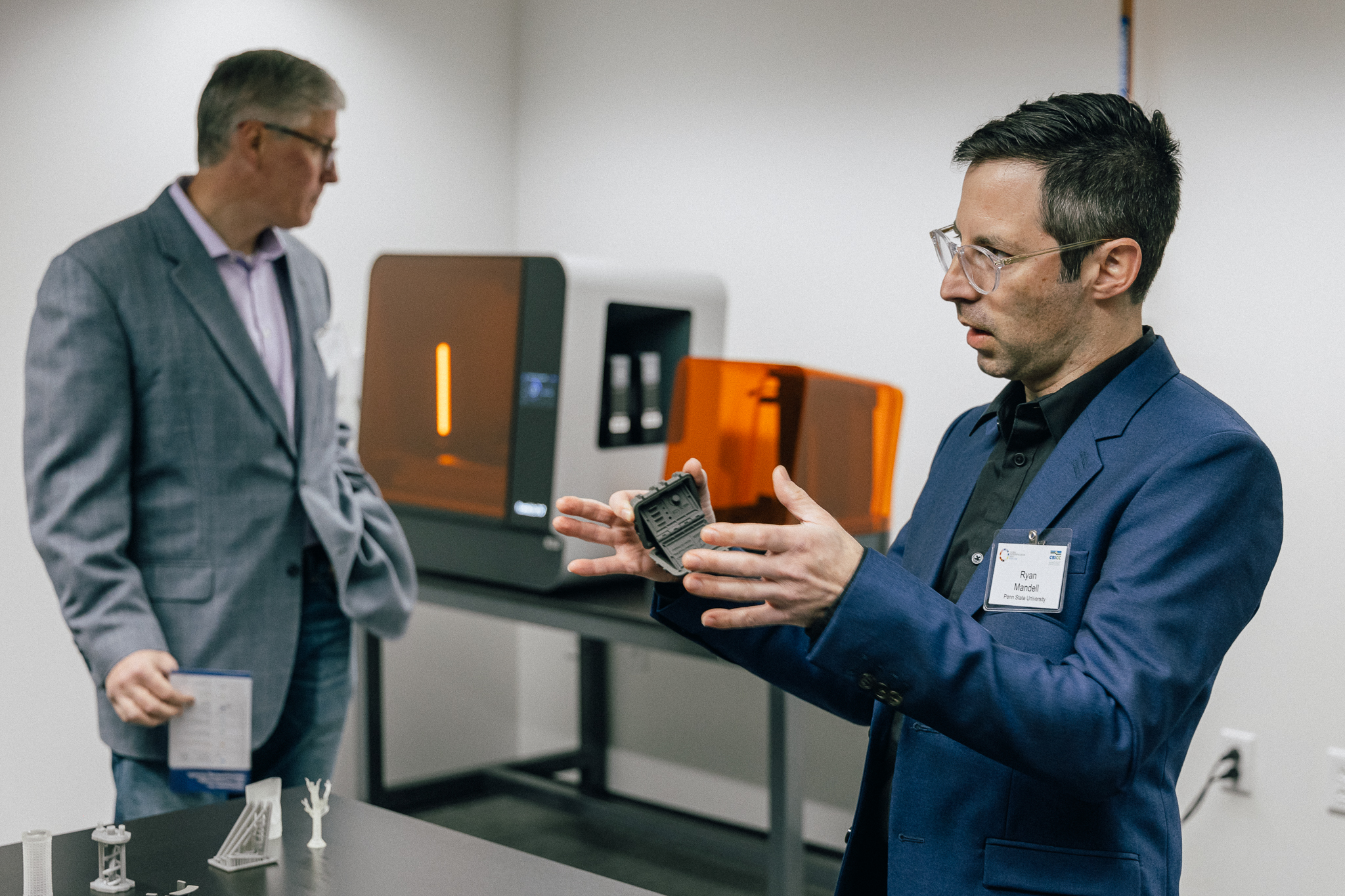 Ryan Mandell, OriginLabs Director, speaking with manufacturing equipment in the background