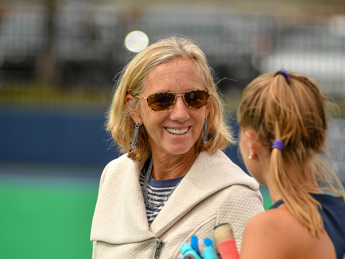 Char Morett-Curtiss smiles as she talks with a player