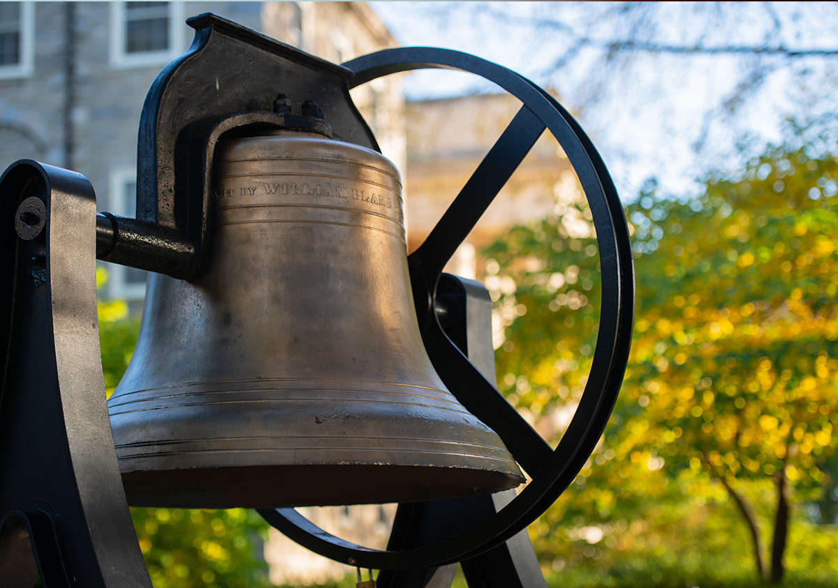 A bell with green foliage visible in the background. 