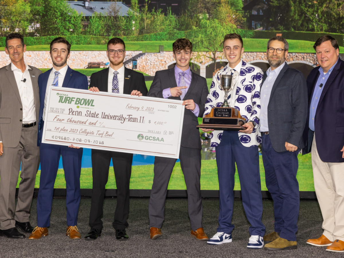 Penn State Turf Club lined up and smiling at the camera with their prize