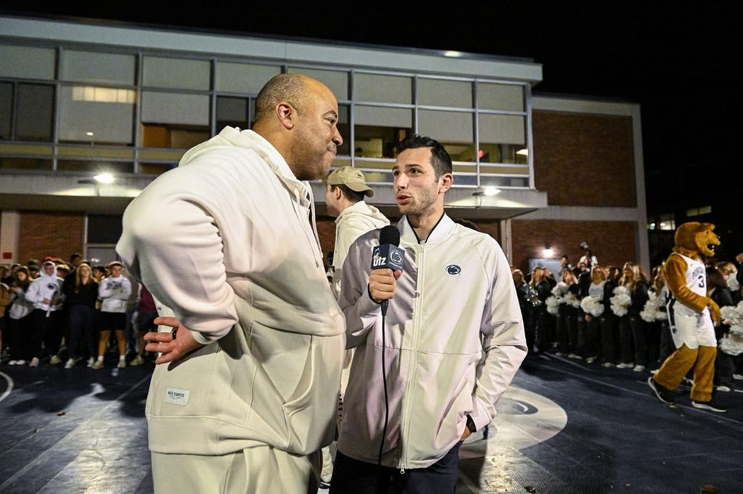 Student with microphone in hand interviews coach