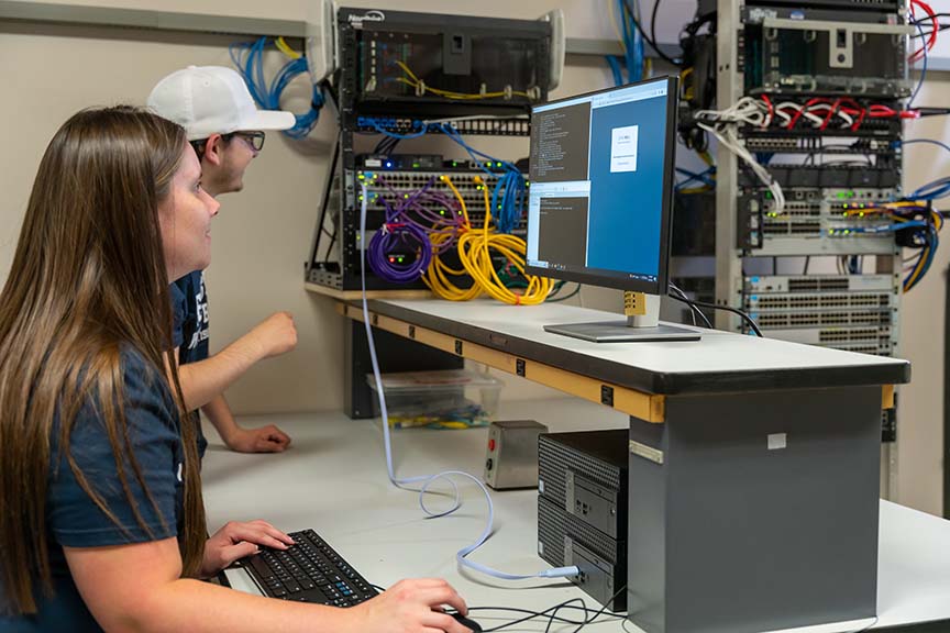 Two students looking at a computer monitor