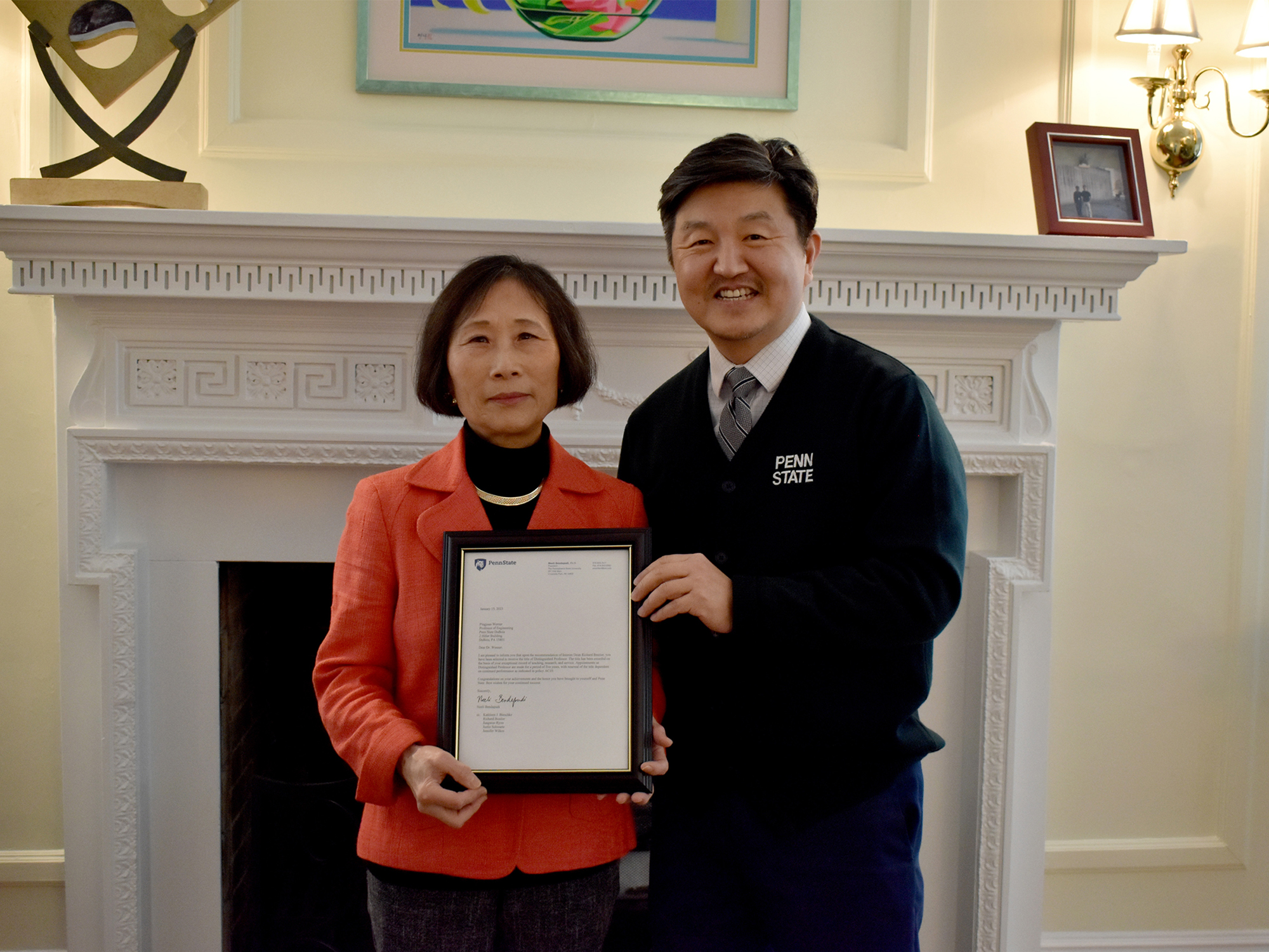 Jungwoo Ryoo is presenting Pingjuan Werner with a framed letter