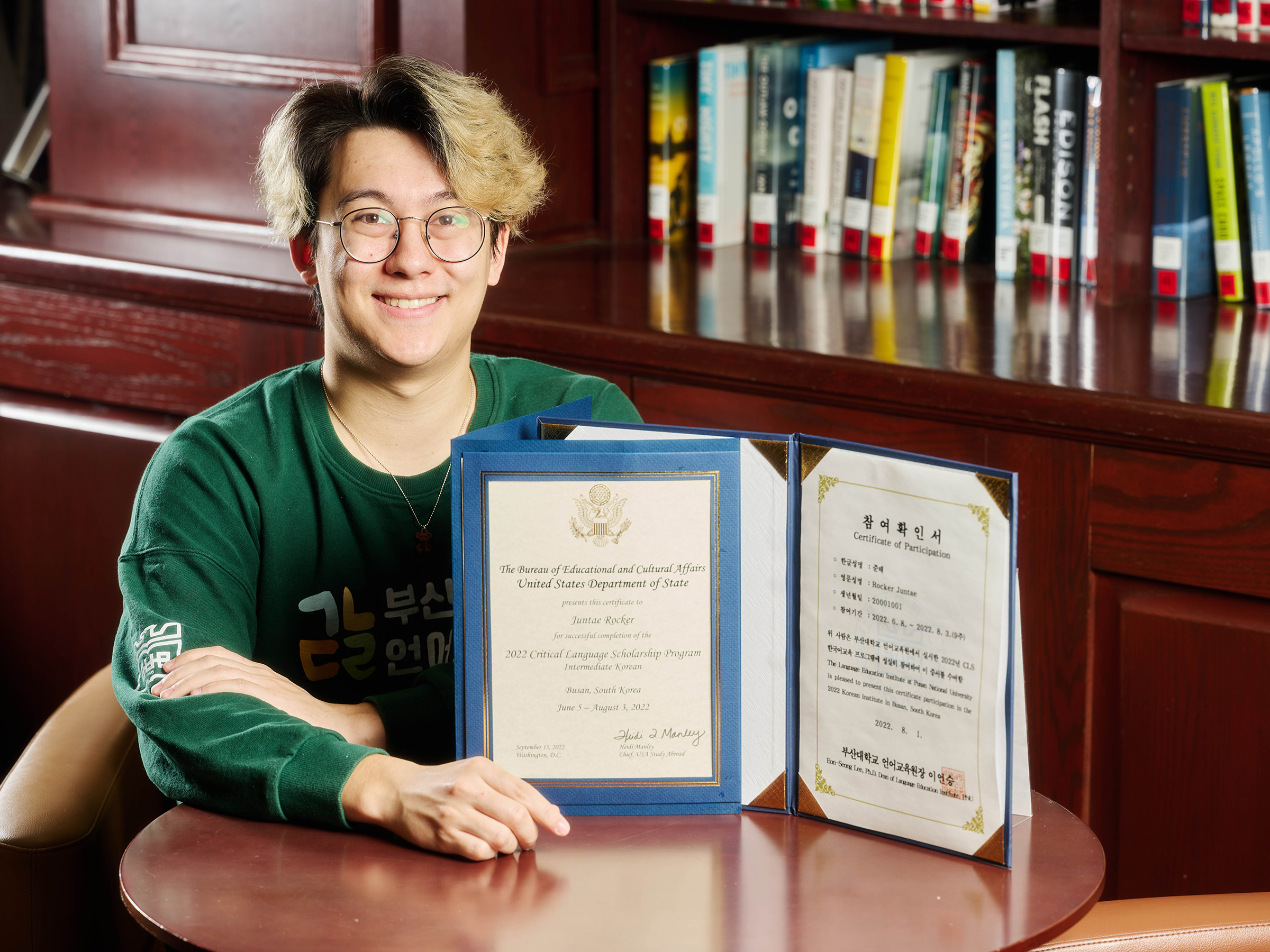 juntae rocker posing for a photo with certificates from his study abroad program in south korea