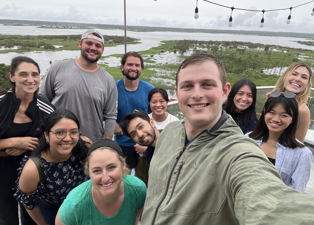 A male student is taking a selfie with his classmates and teacher during their time in Peru. 