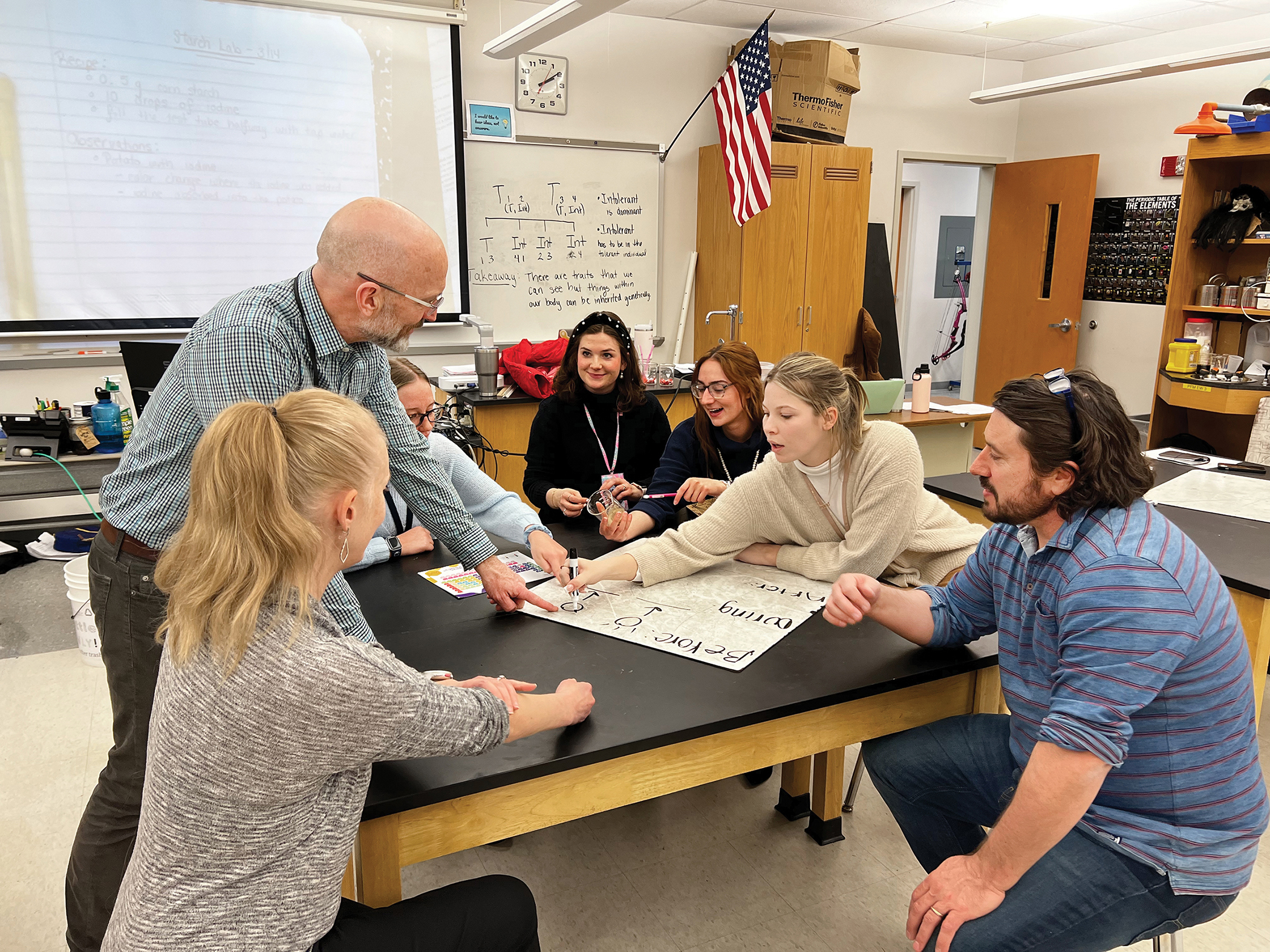 Scott McDonald leads a discussion with students seated around a table.