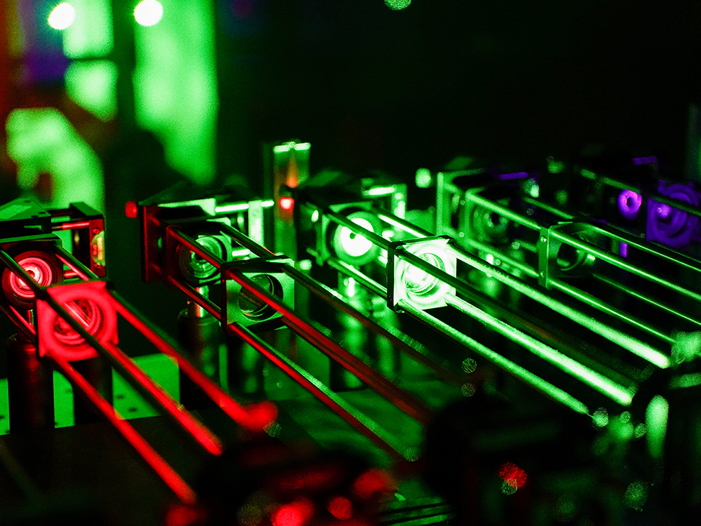 Small metal tubes are lit up by red and green lights.