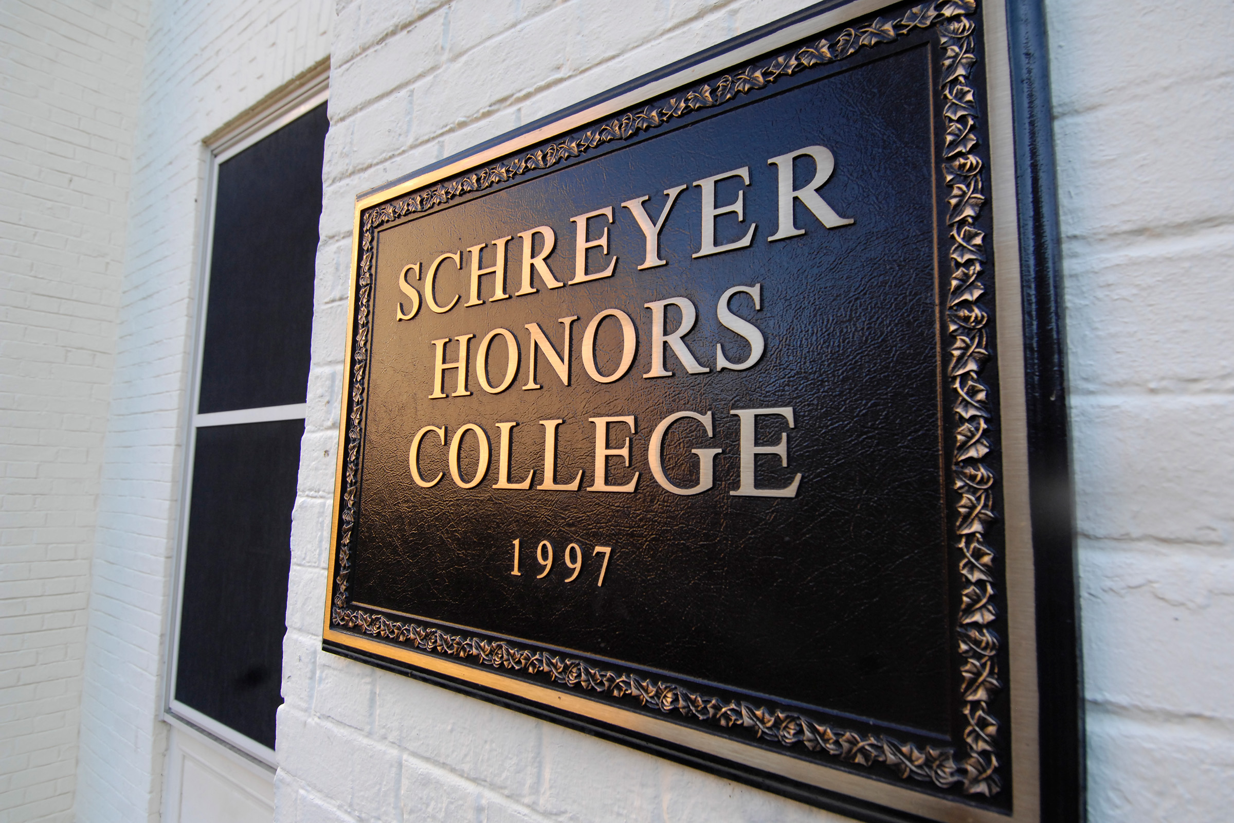 plaque that reads "schreyer honors college 1997"