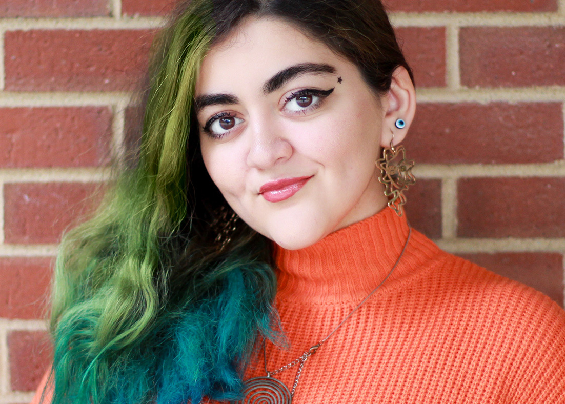 Aysan Jafarzadeh's headshot against a brick background.