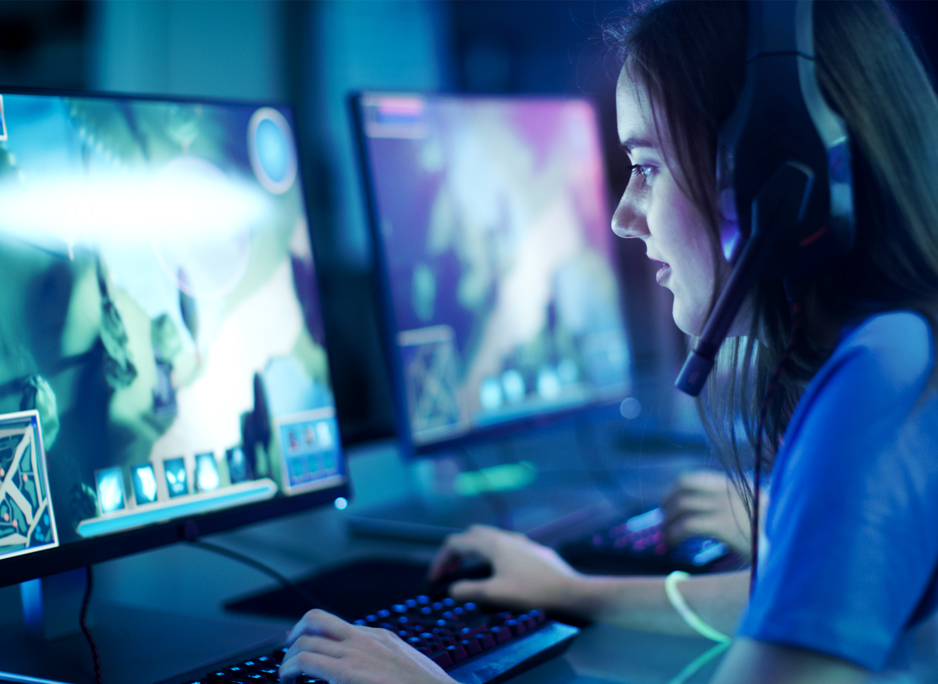 dark-haired teenage girl wearing headphones plays computer game