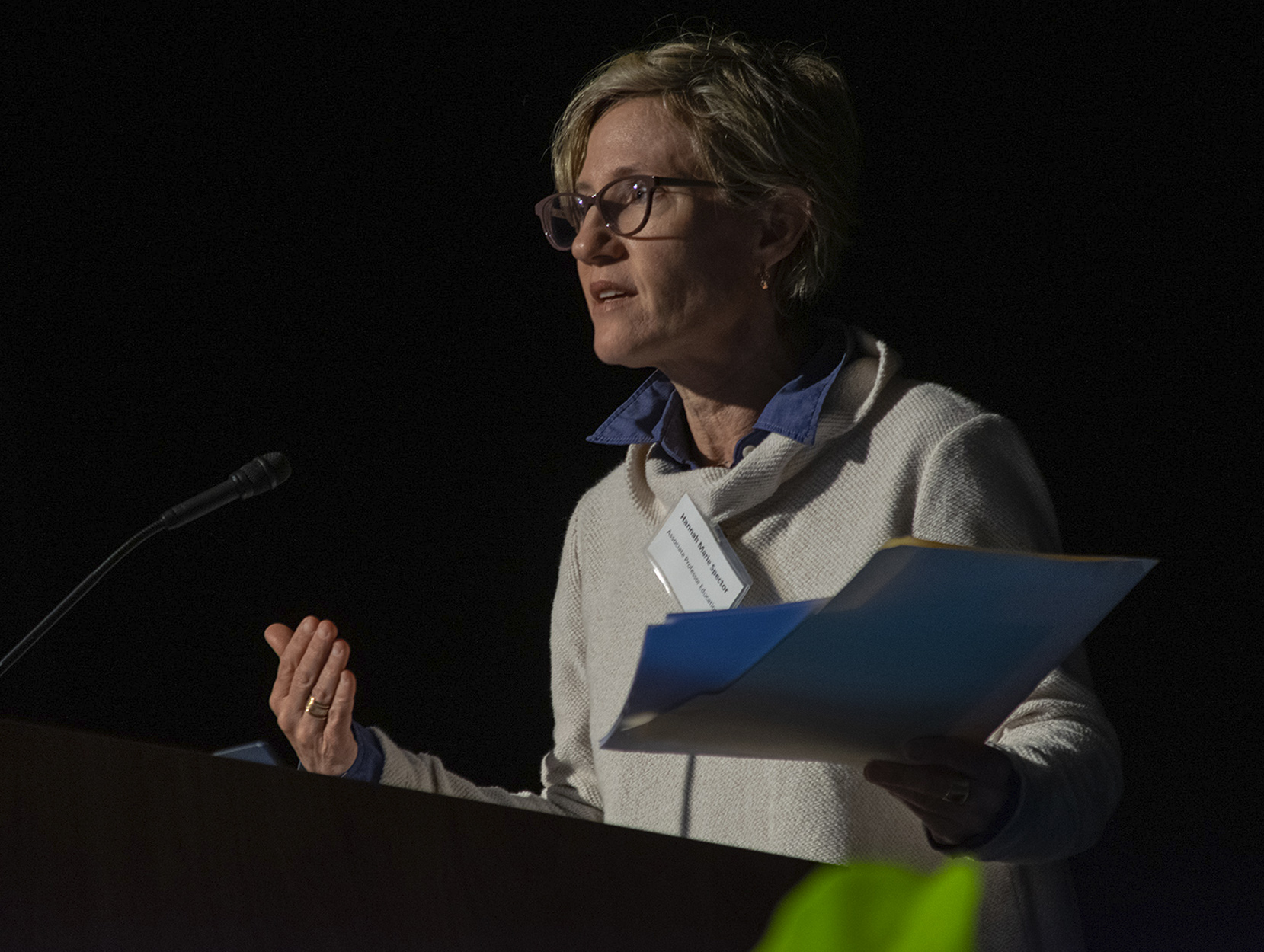 Hannah Spector speaks into a microphone at a lectern