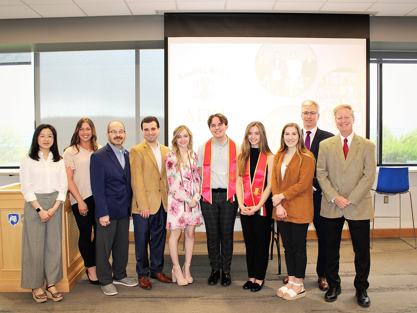 new inductees into lamda pi eta pose for a group photo