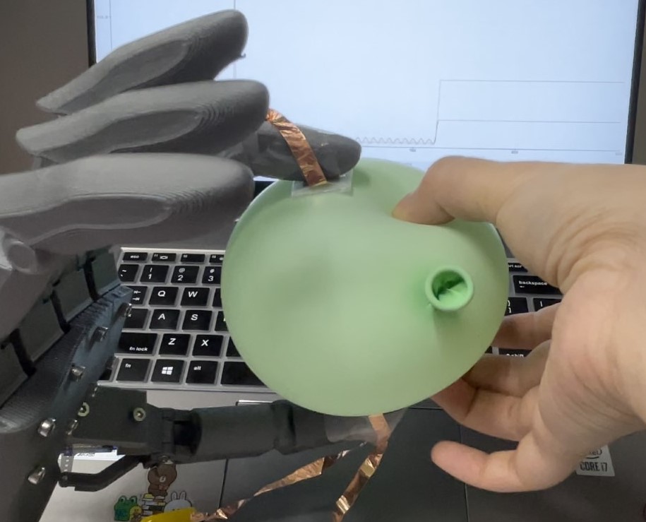 robotic hand squeezing a balloon