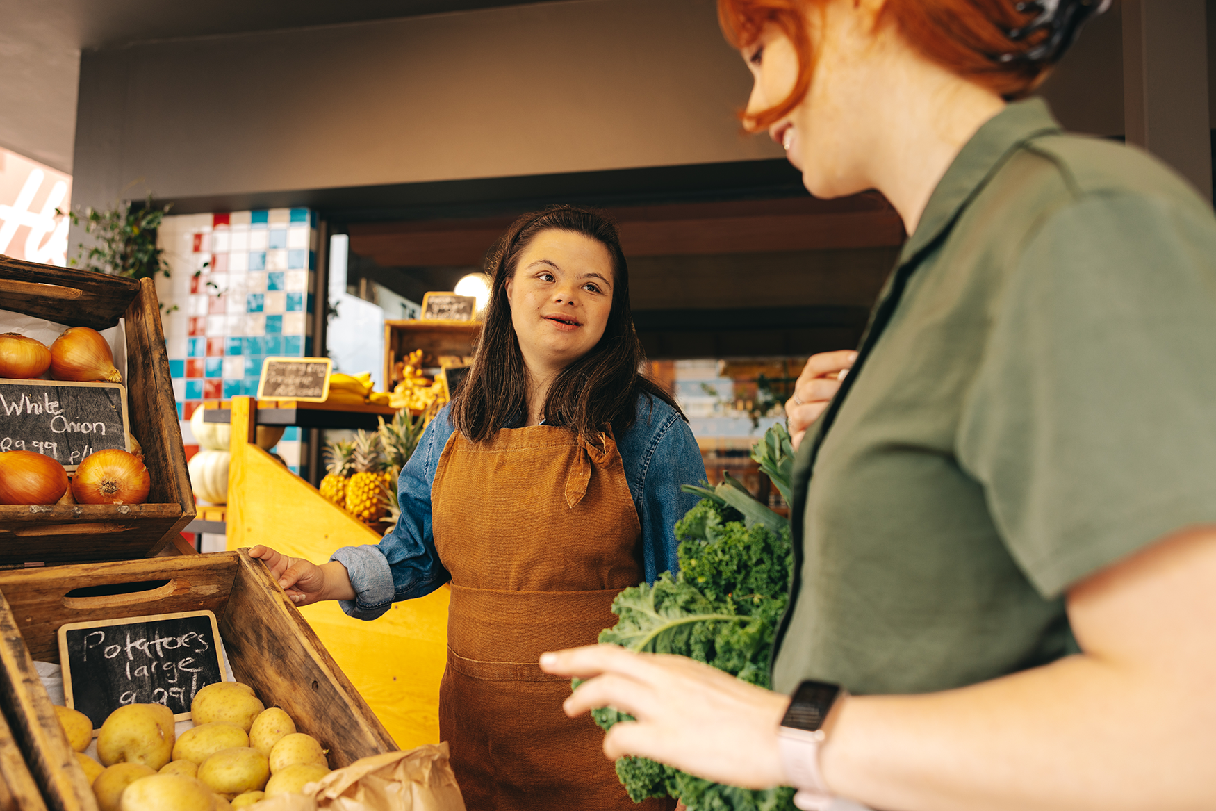 A young woman with Down syndrome assisting a customer in a grocery store. 