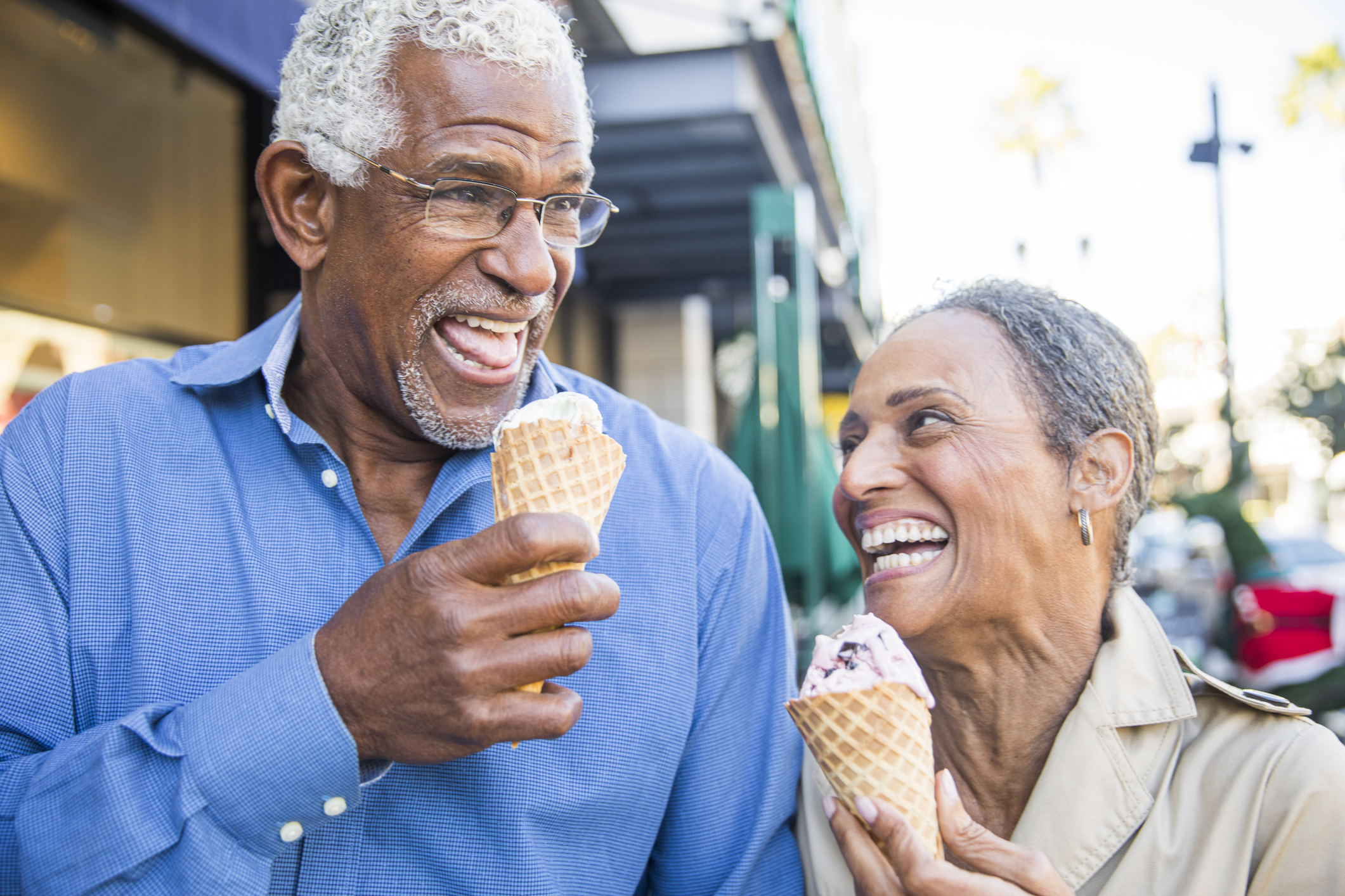 Older Black man and woman eating ice cream and smiling