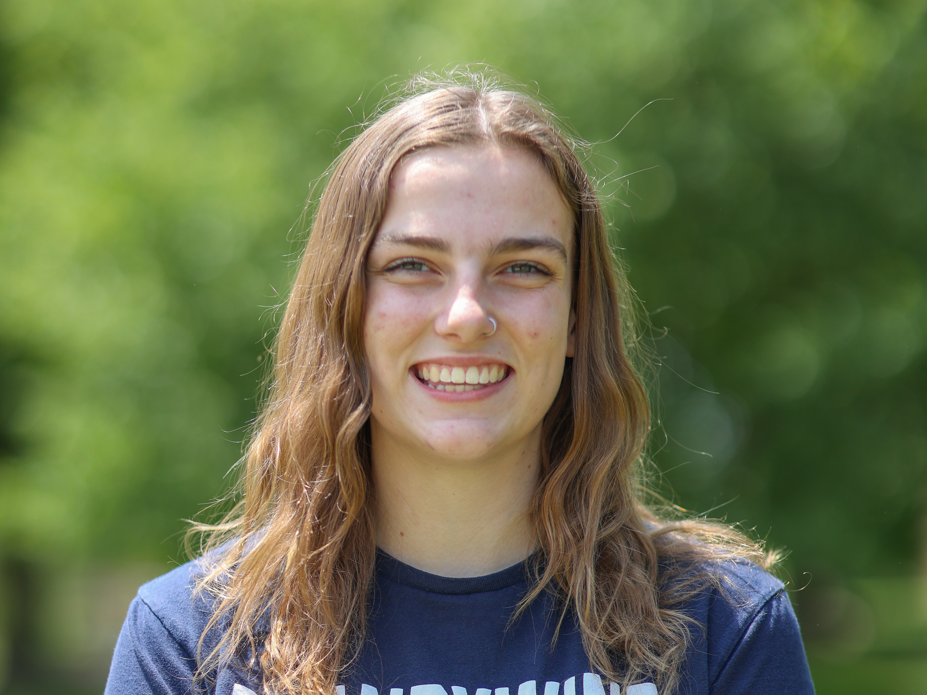 woman smiling in front of trees