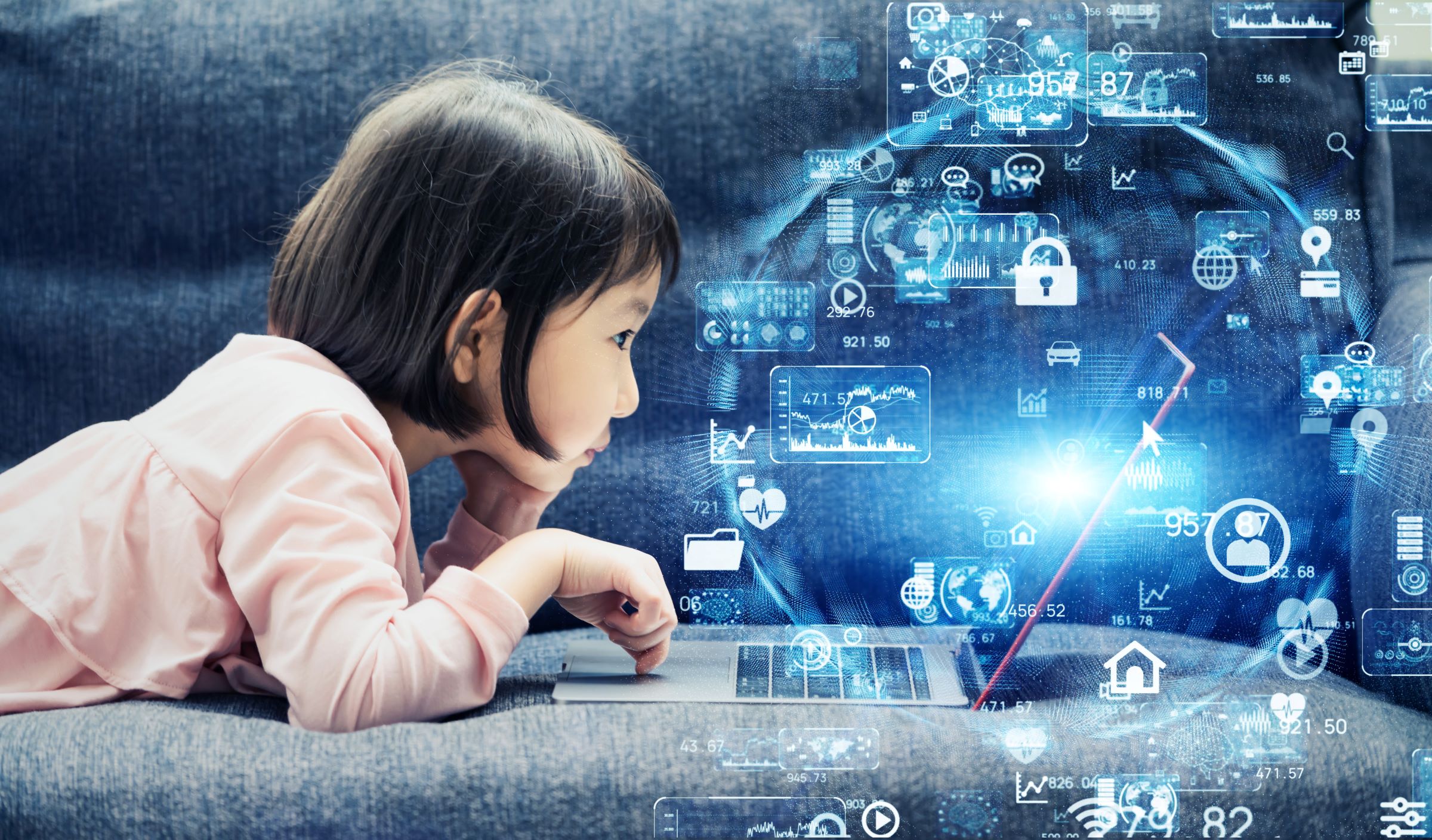 young girl with dark hair and pink shirt playing on laptop