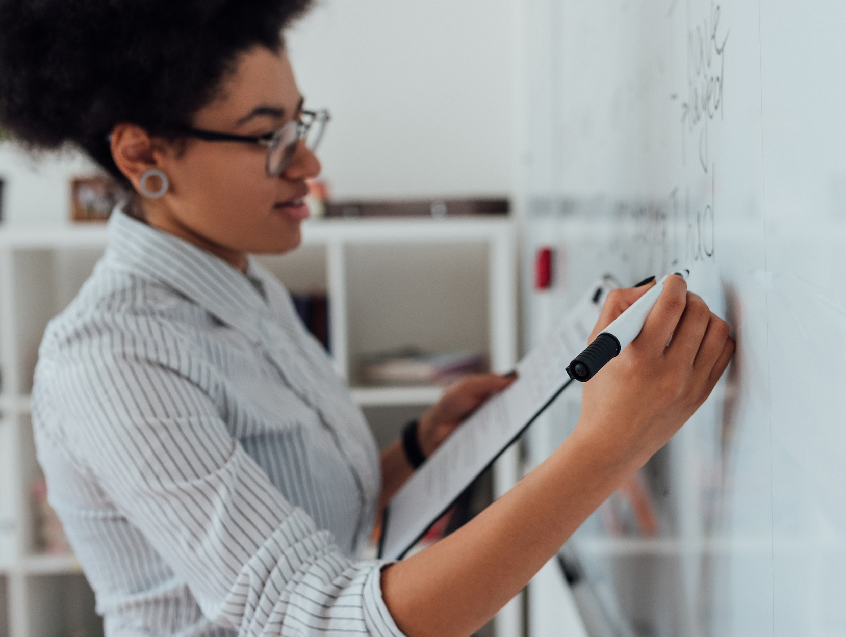 Teacher writing on whiteboard