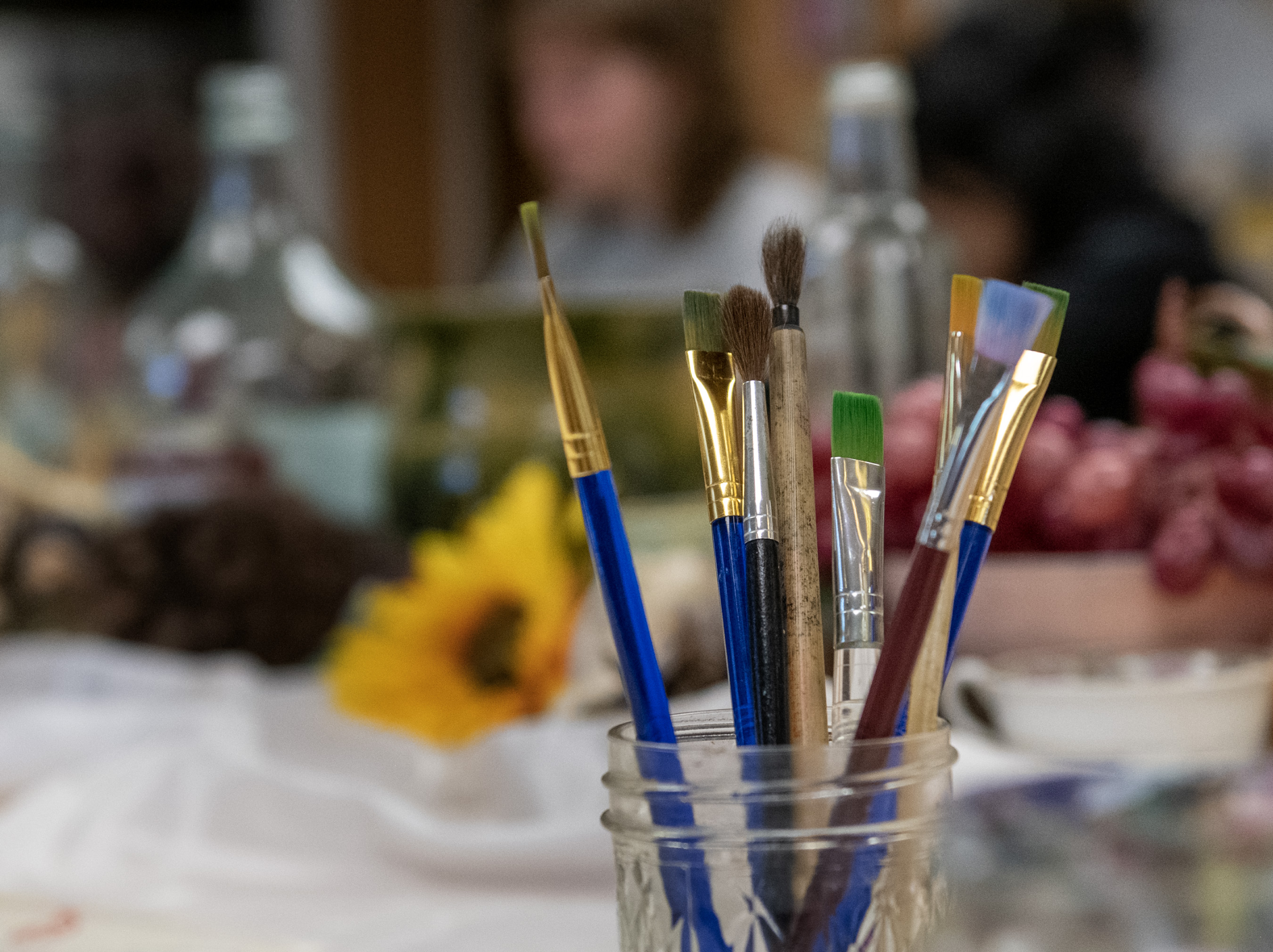 Paintbrushes sit on a craft table in the Center for Arts and Crafts