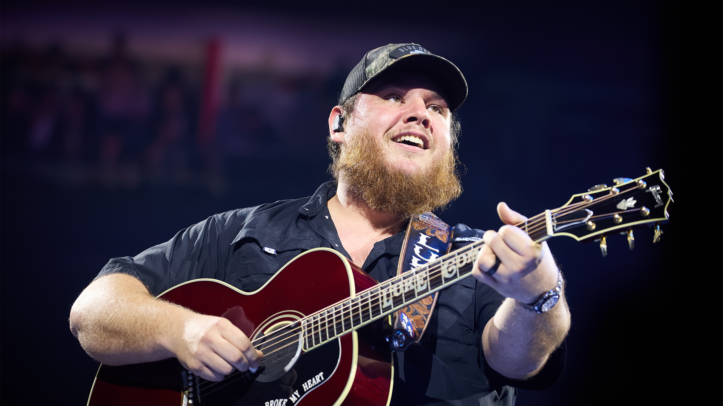 Luke Combs playing guitar and singing.