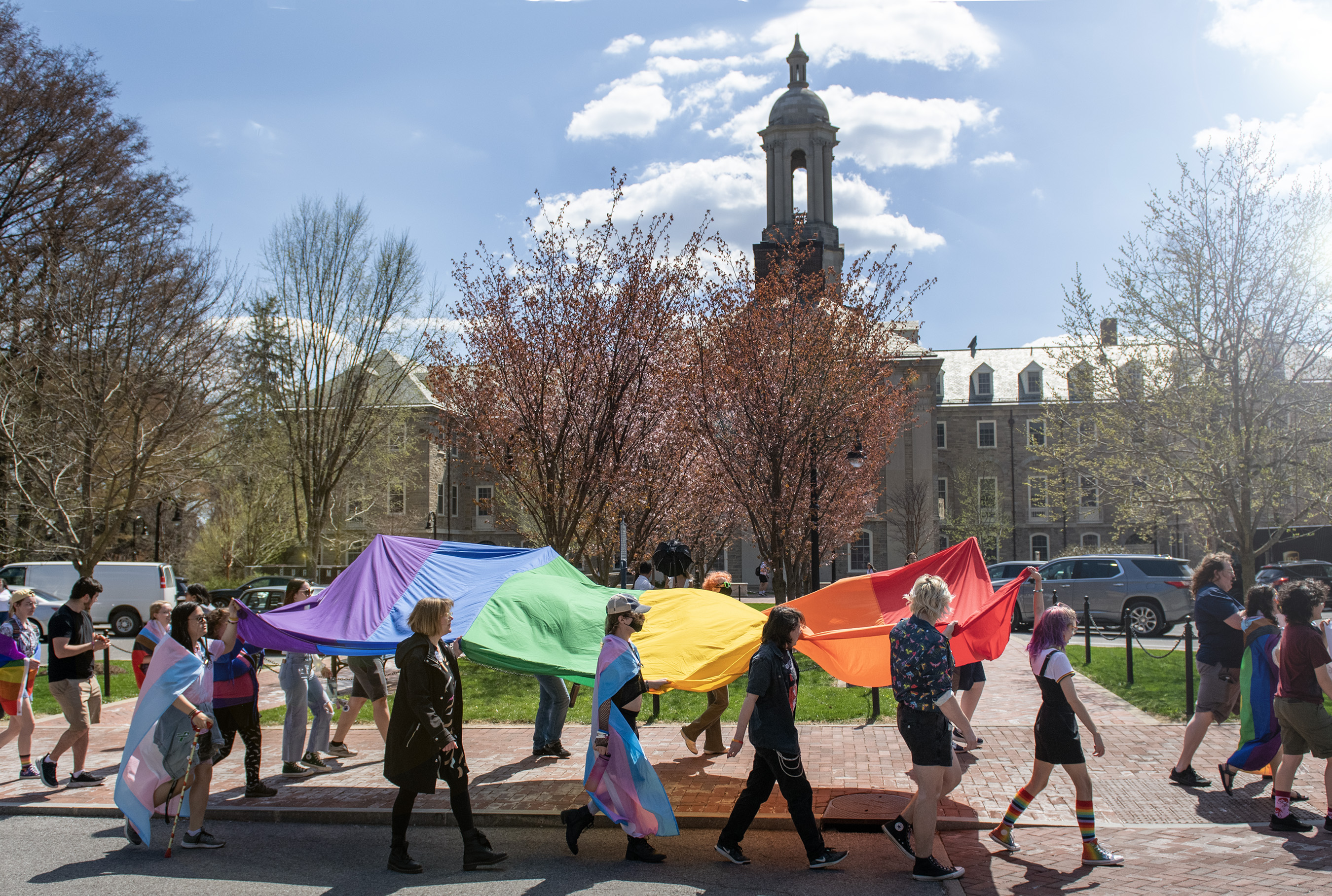 Students and staff march past Old Main during the Pride March in 2023