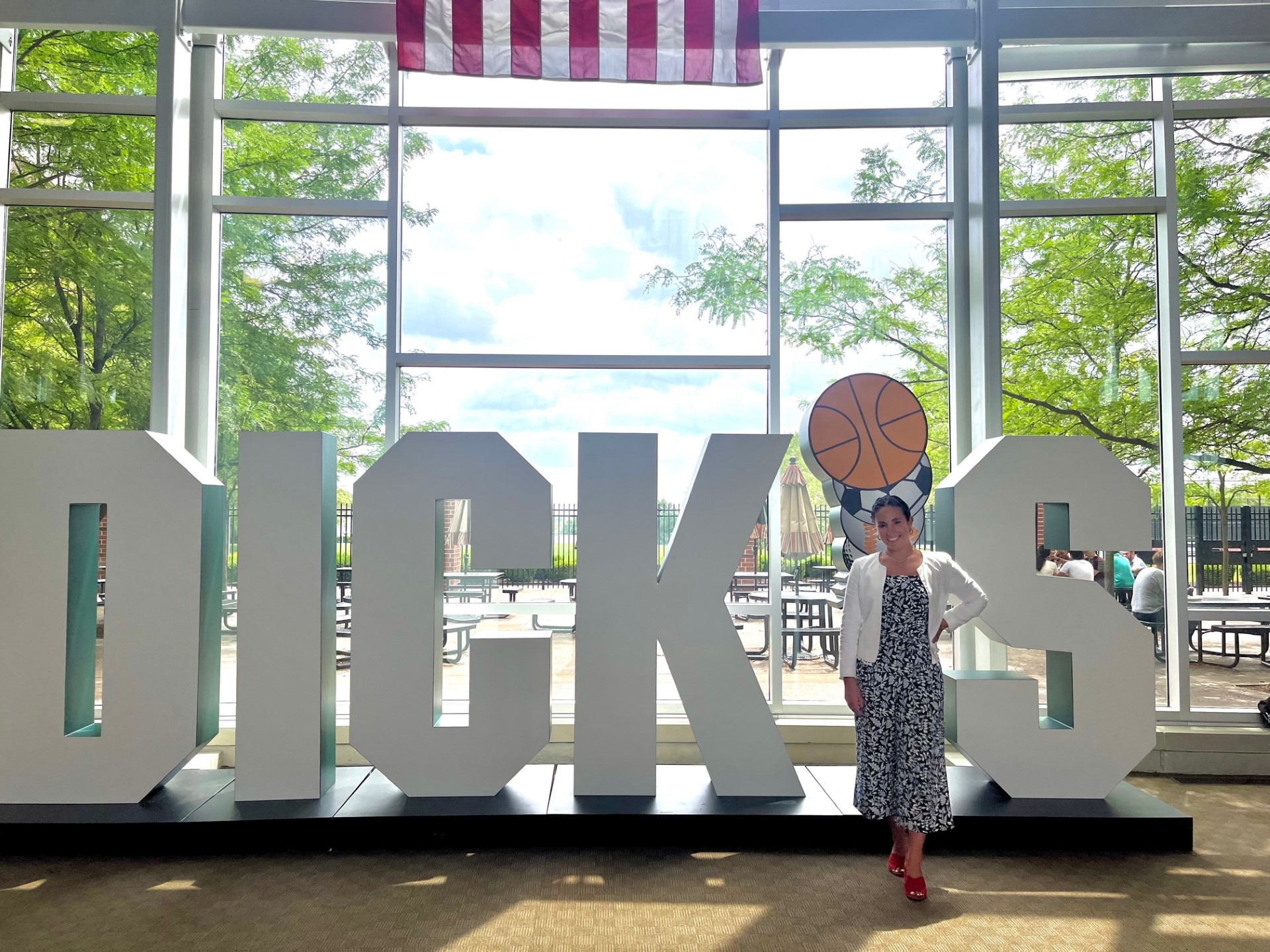 person stands in front of large company logo