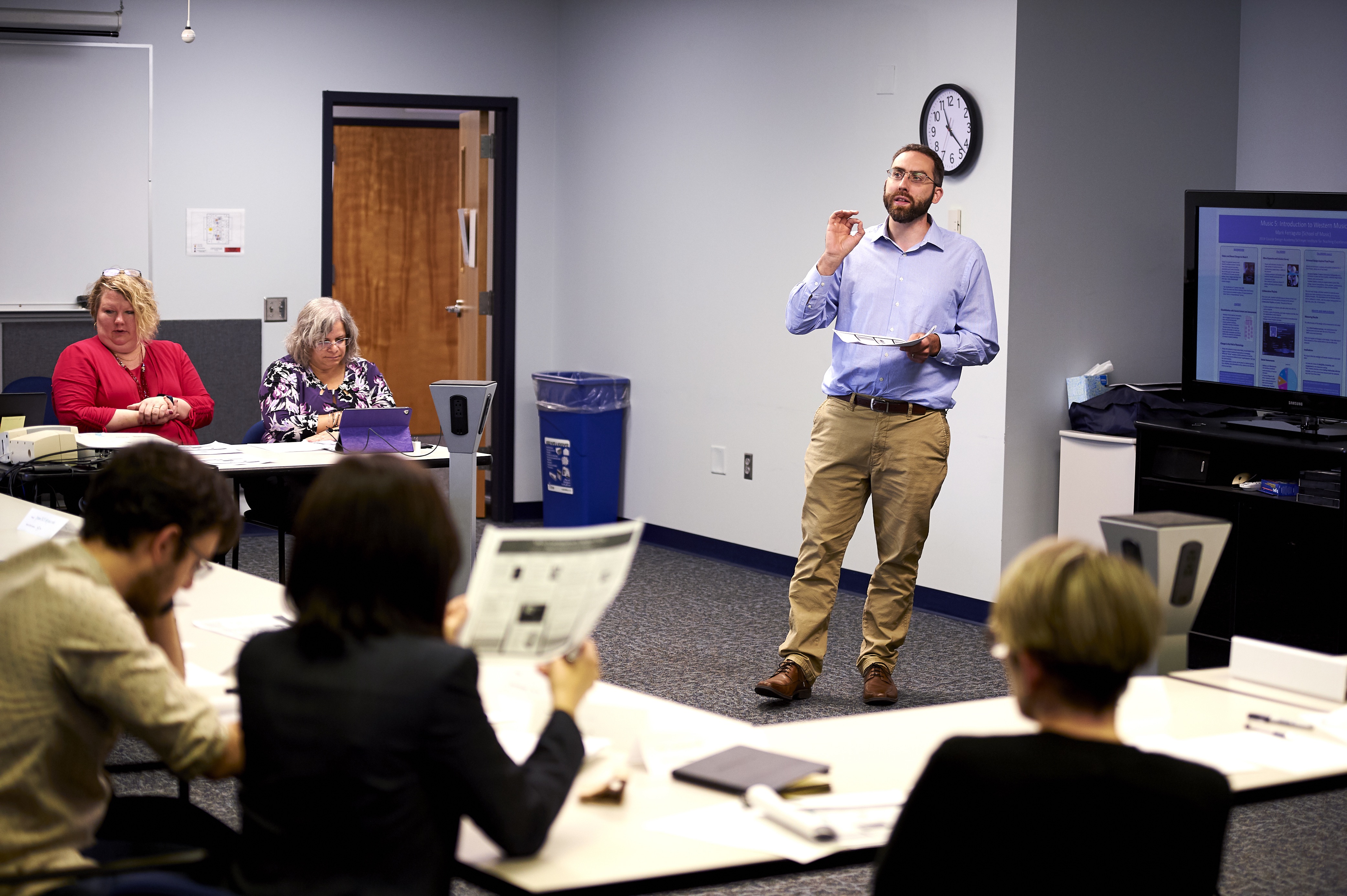 Man leading a workshop with attendees sitting in a U shape around him