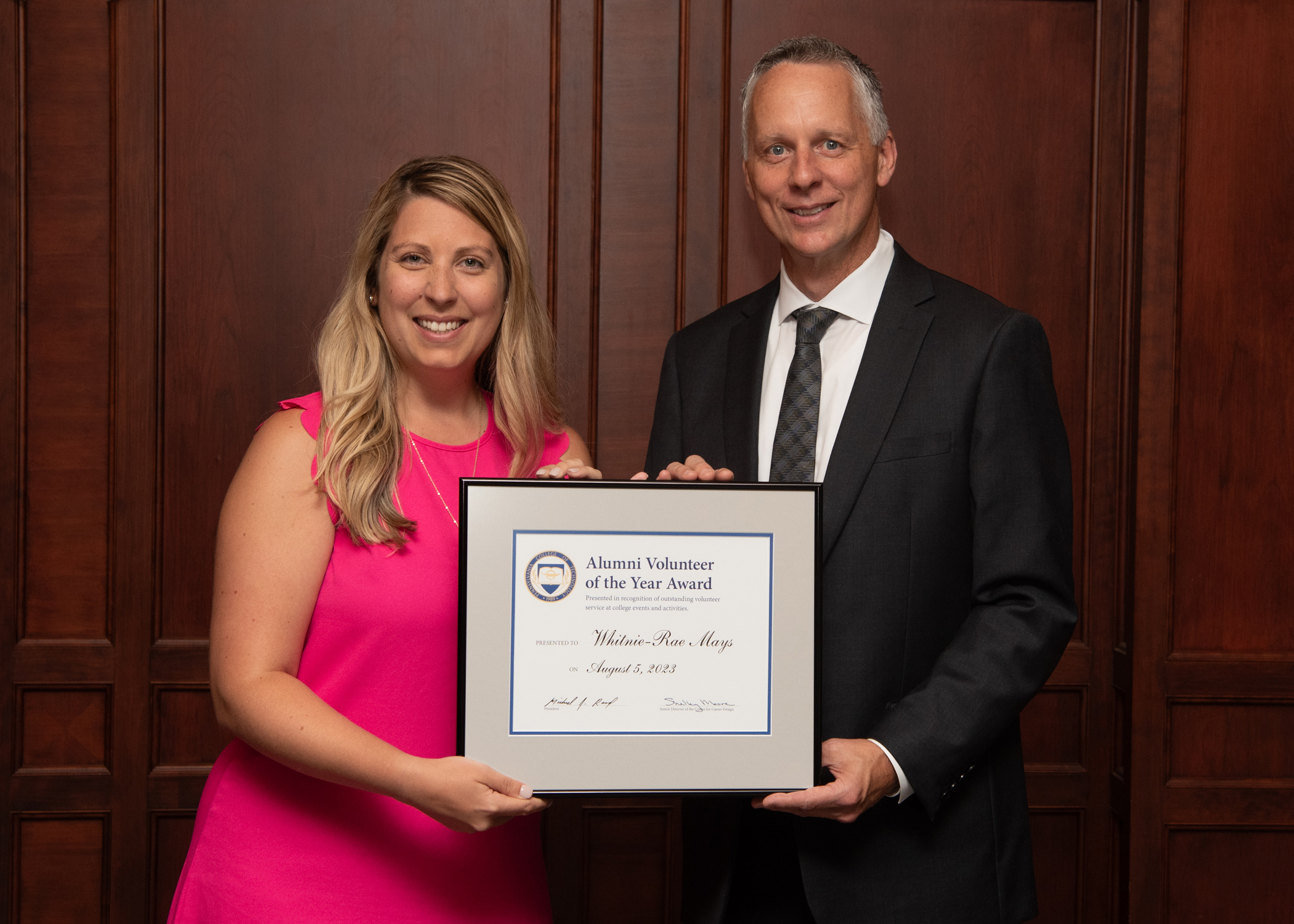 Whitnie-Rae Mays and Michael J. Reed holding a framed certificate between them