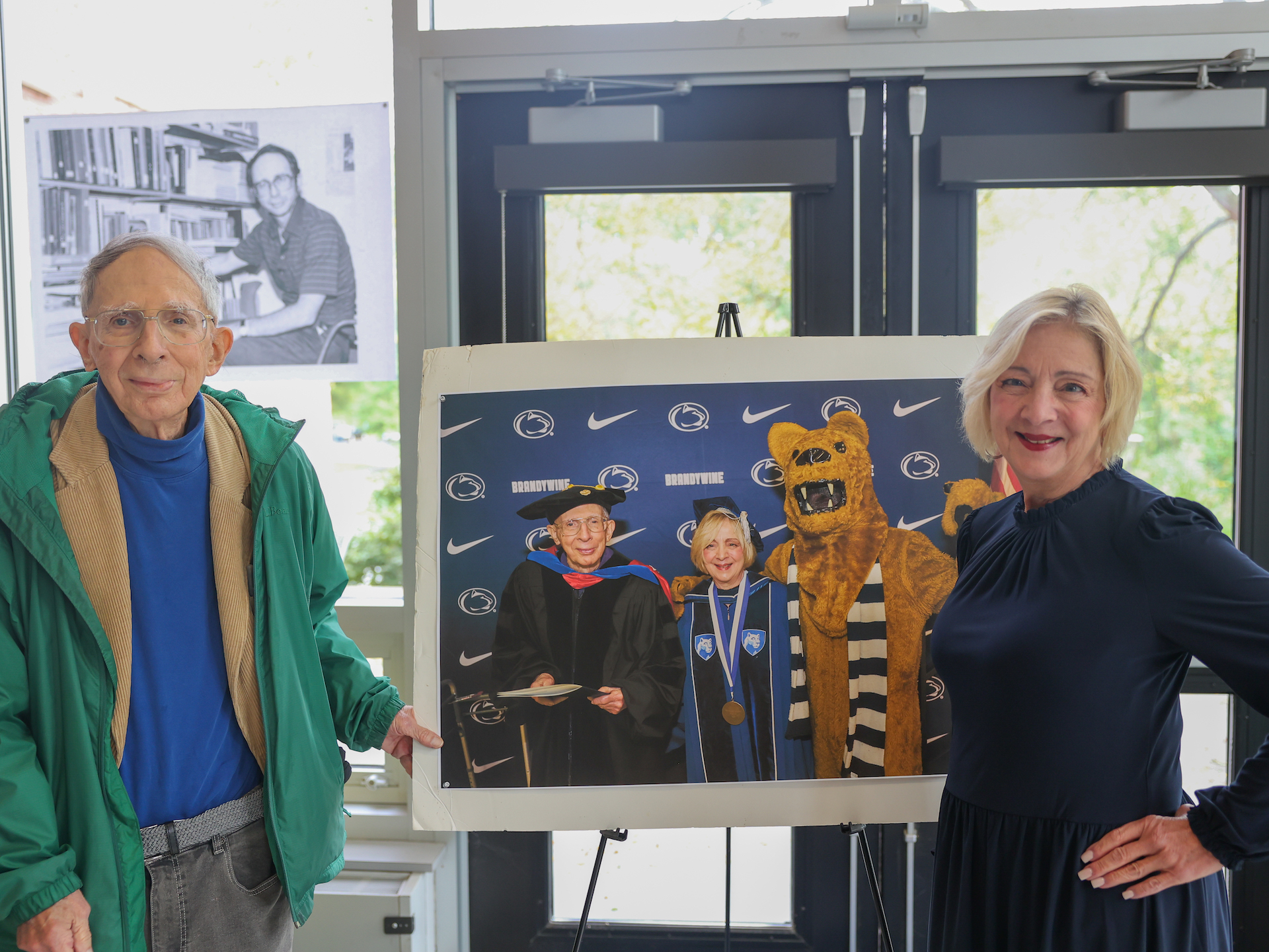 two people smiling in front of photo