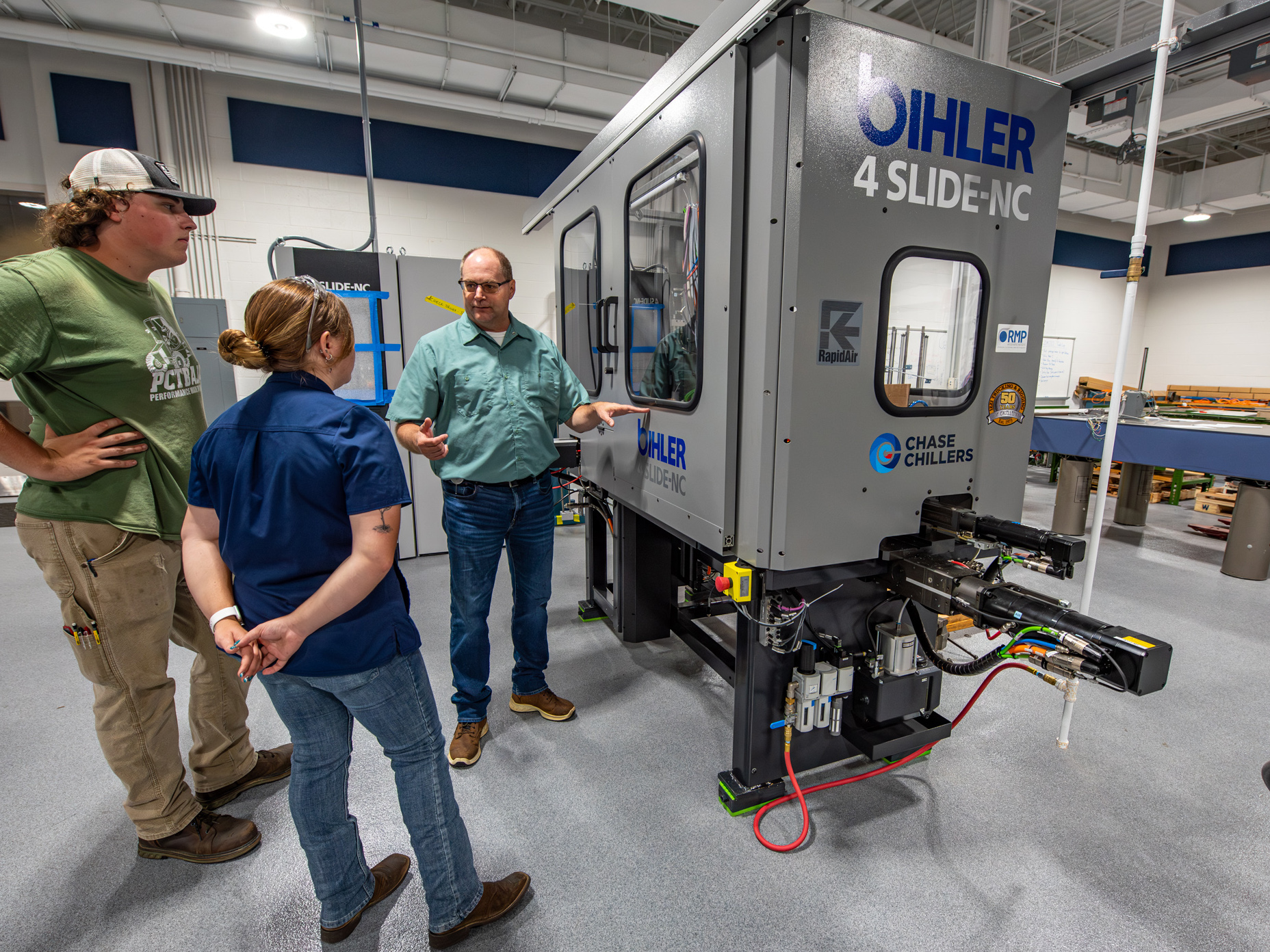 Pennsylvania College of Technology faculty member Howard W. Troup explains the Bihler 4 Slide-NC to Penn College students Trevor J. Lindsay and Genevive J. Yamelski.