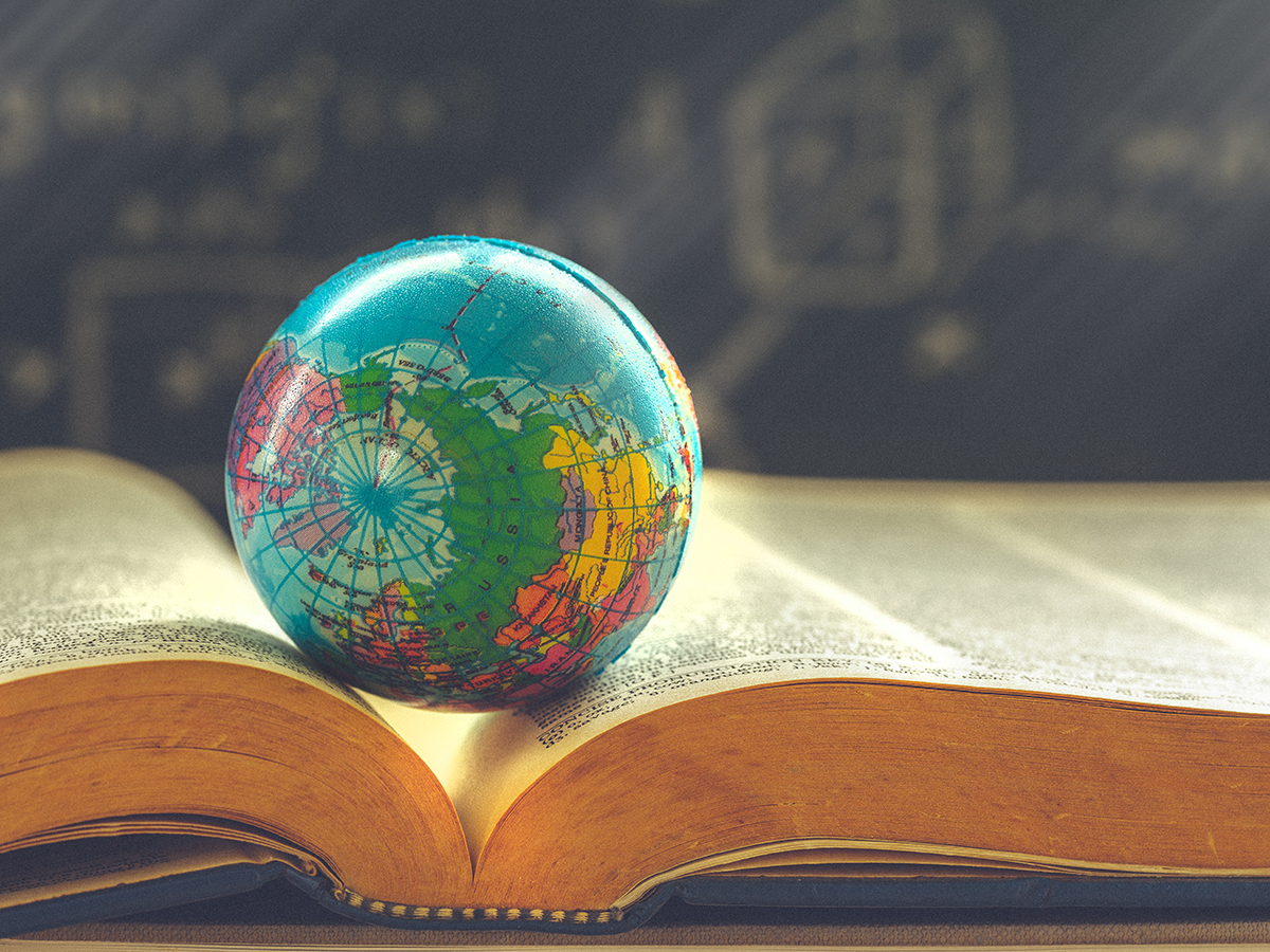 A small globe sitting on top of a book