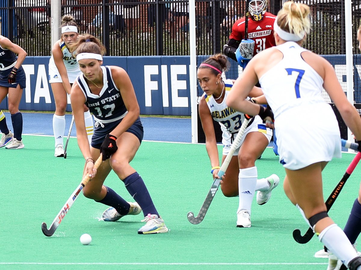 Penn State field hockey player maneuvers around defenders