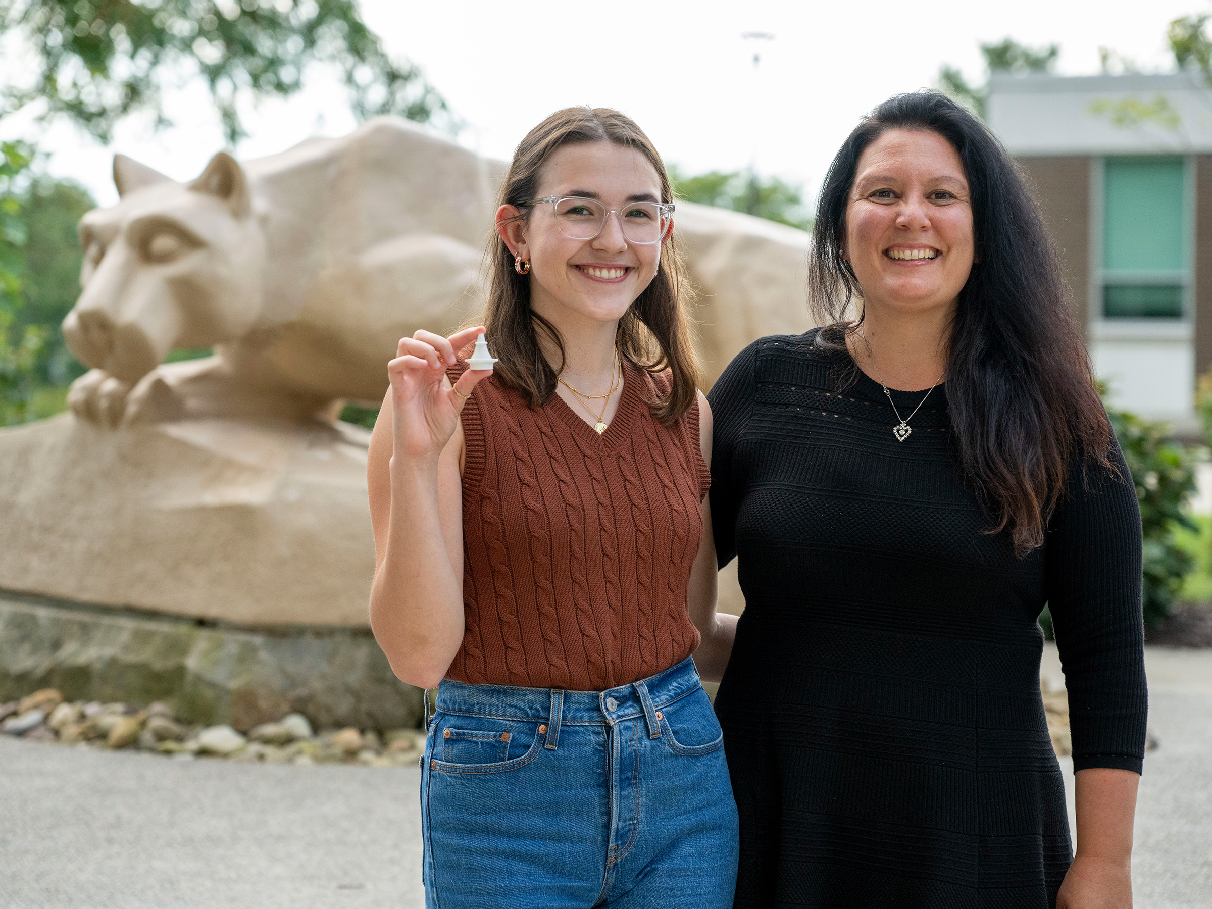 Erdely and Kaplan standing in front of Penn State Fayette's lion shrine.