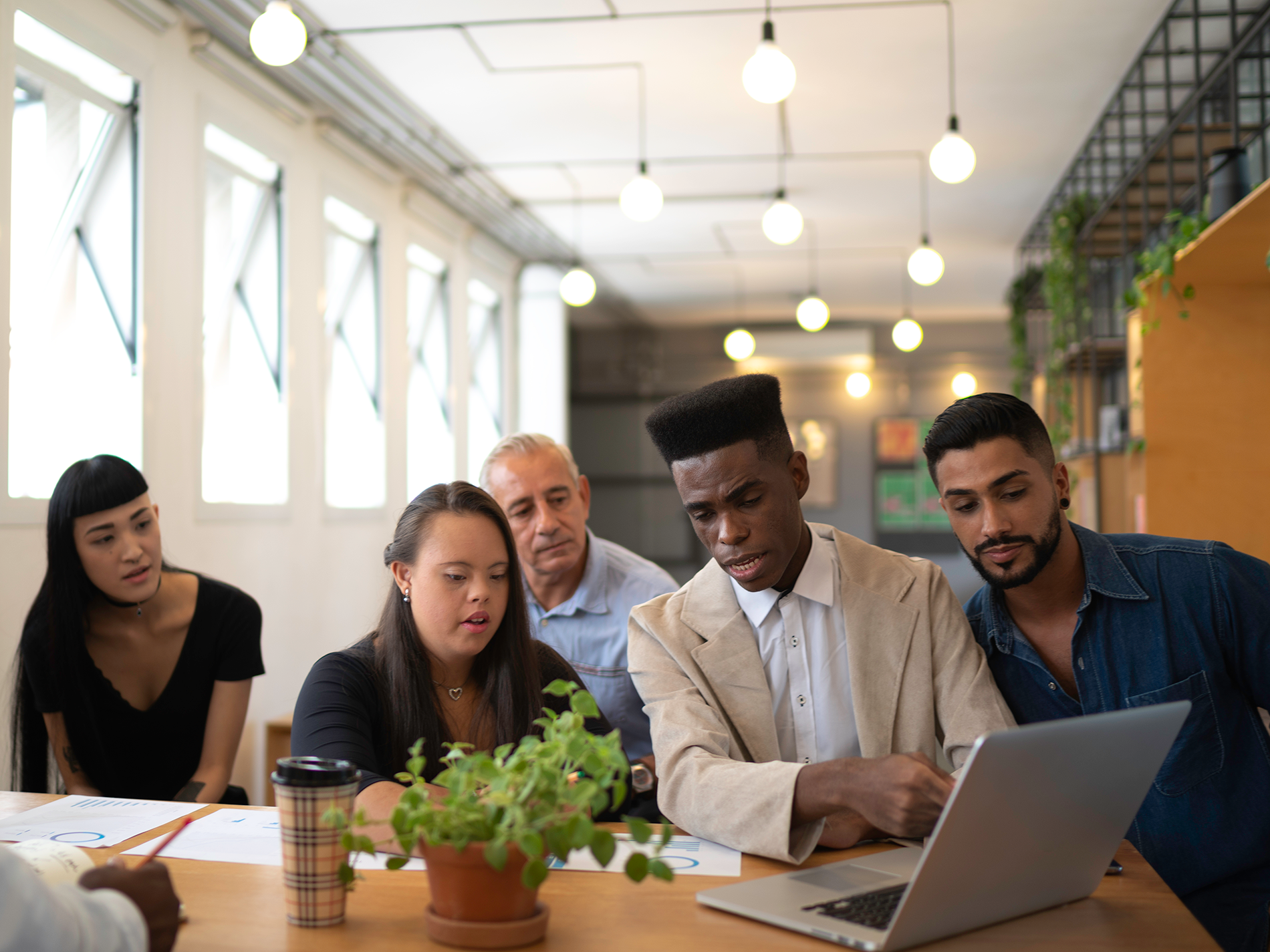 Business team using laptop in office setting.