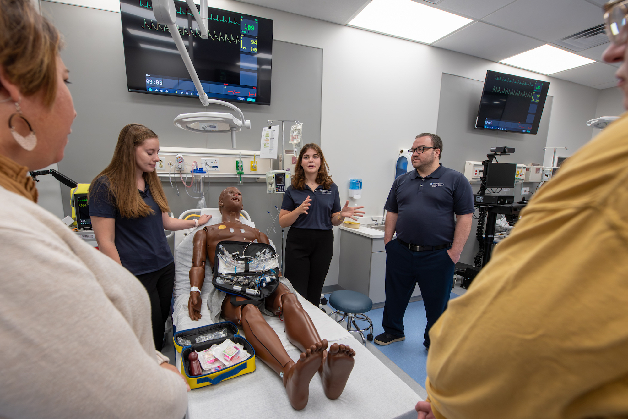 Penn College students in the college's Emergency Medicine Lab with a manikin that serves as a patient simulator