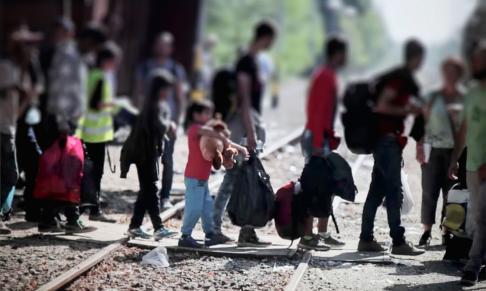 A group of people carrying their belongings with them and walking