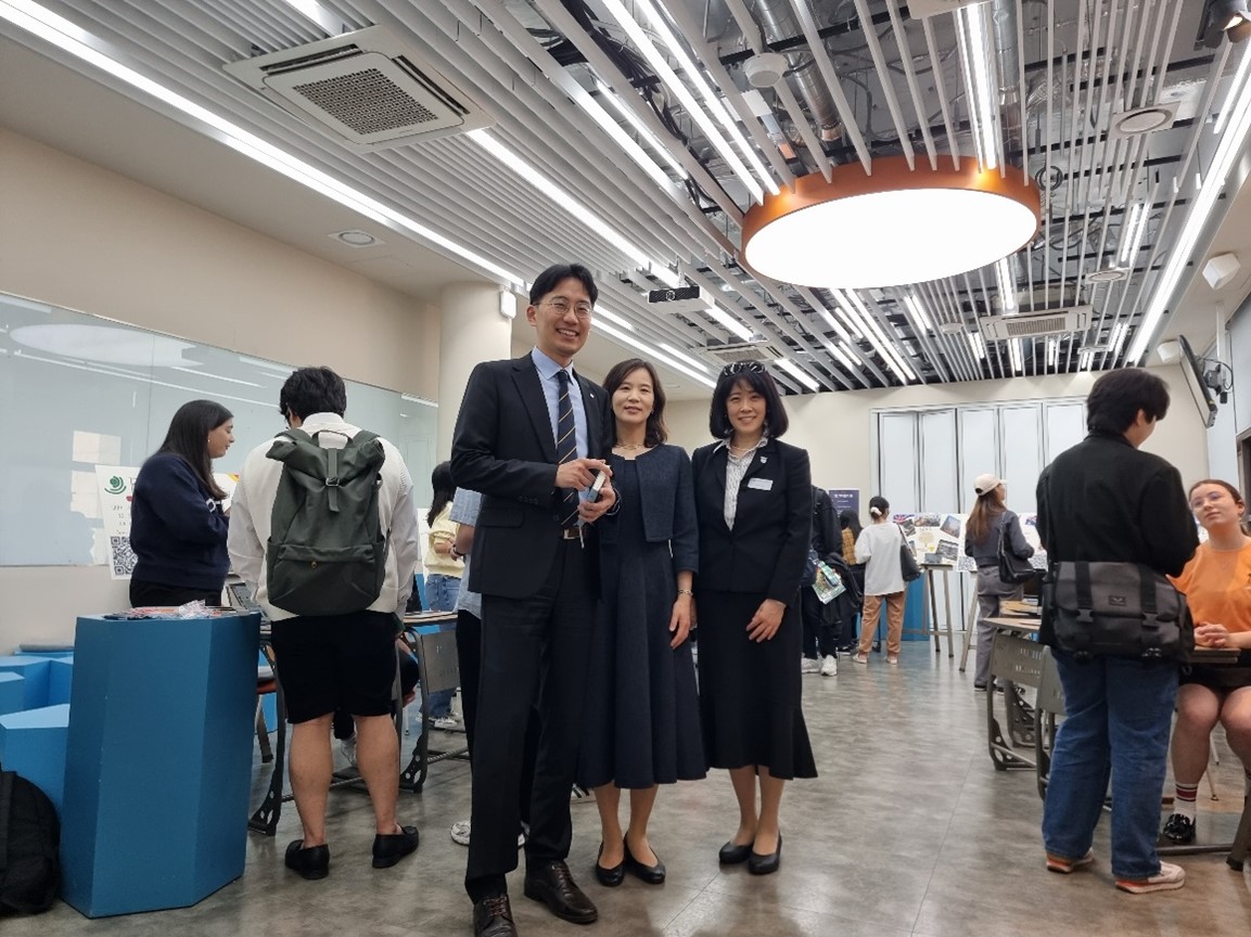 Three people standing in a crowded lab