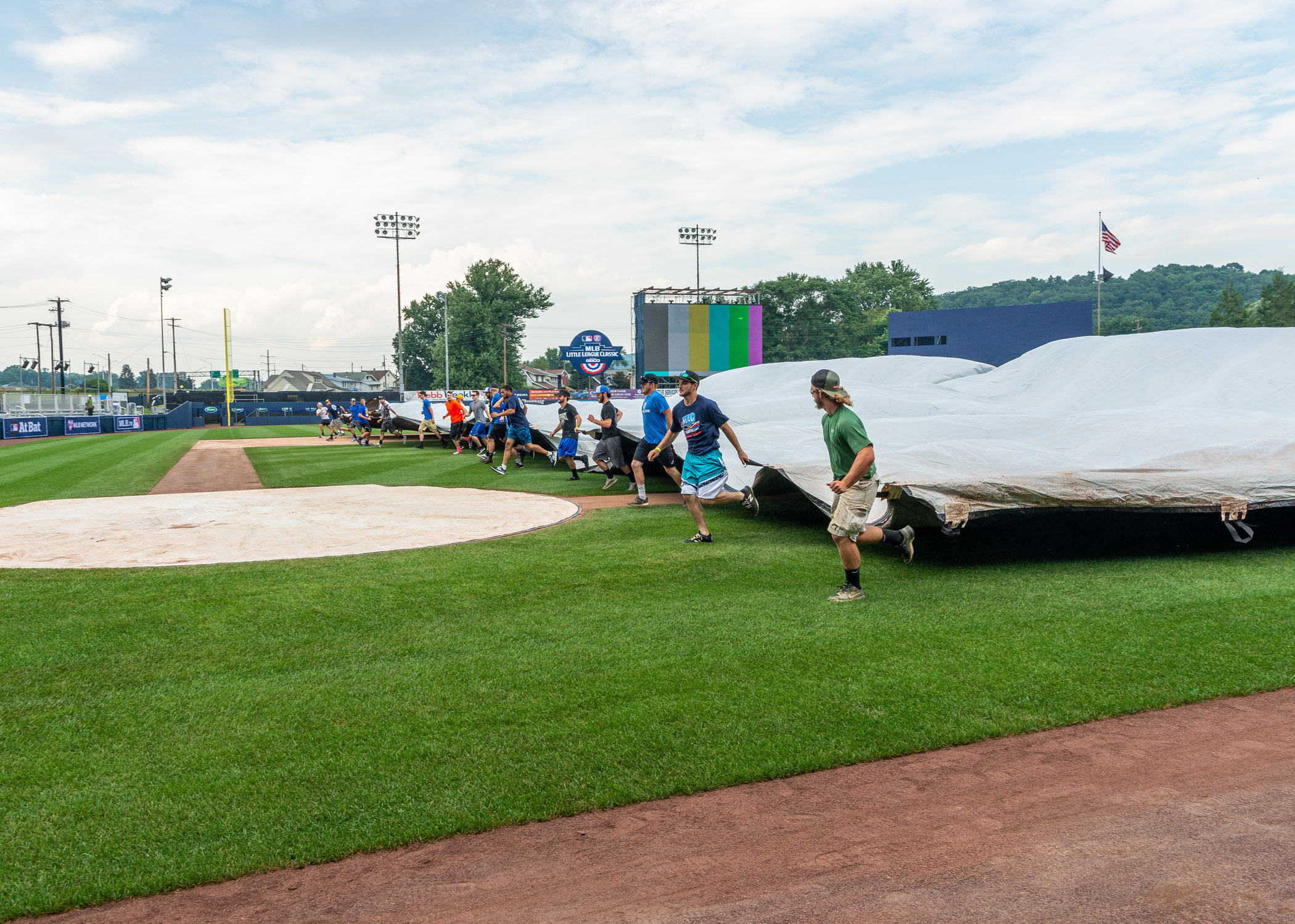 a baseball team practice tarp skills on a field