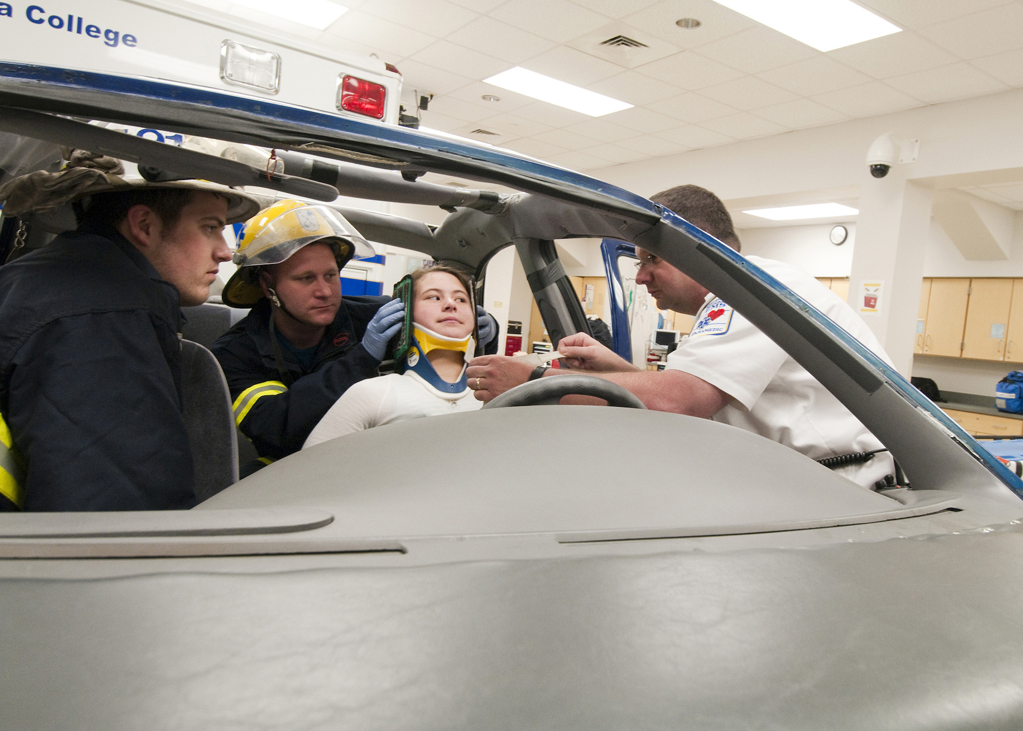 Student EMTs help a person injured in a car accident during a mock training. 