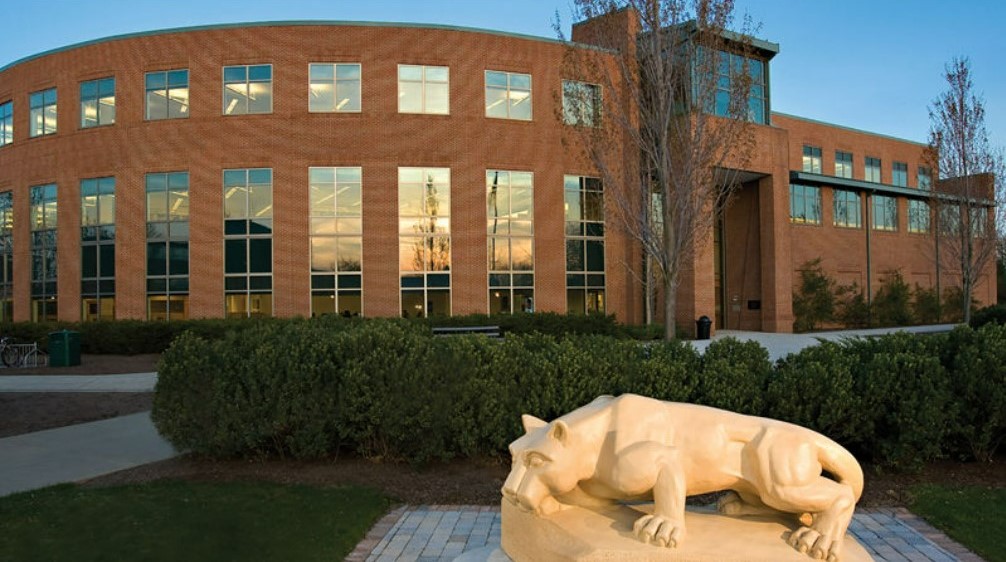 exterior of two-story brick building rounded on one side with tall thin glass windows