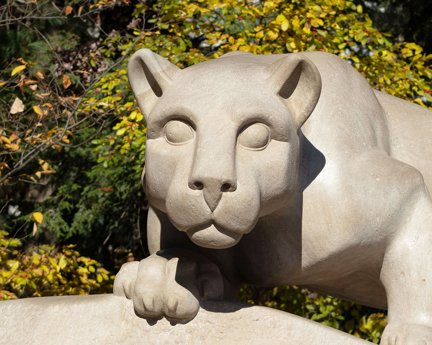 The Nittany Lion Shrine with fall foliage in the background.